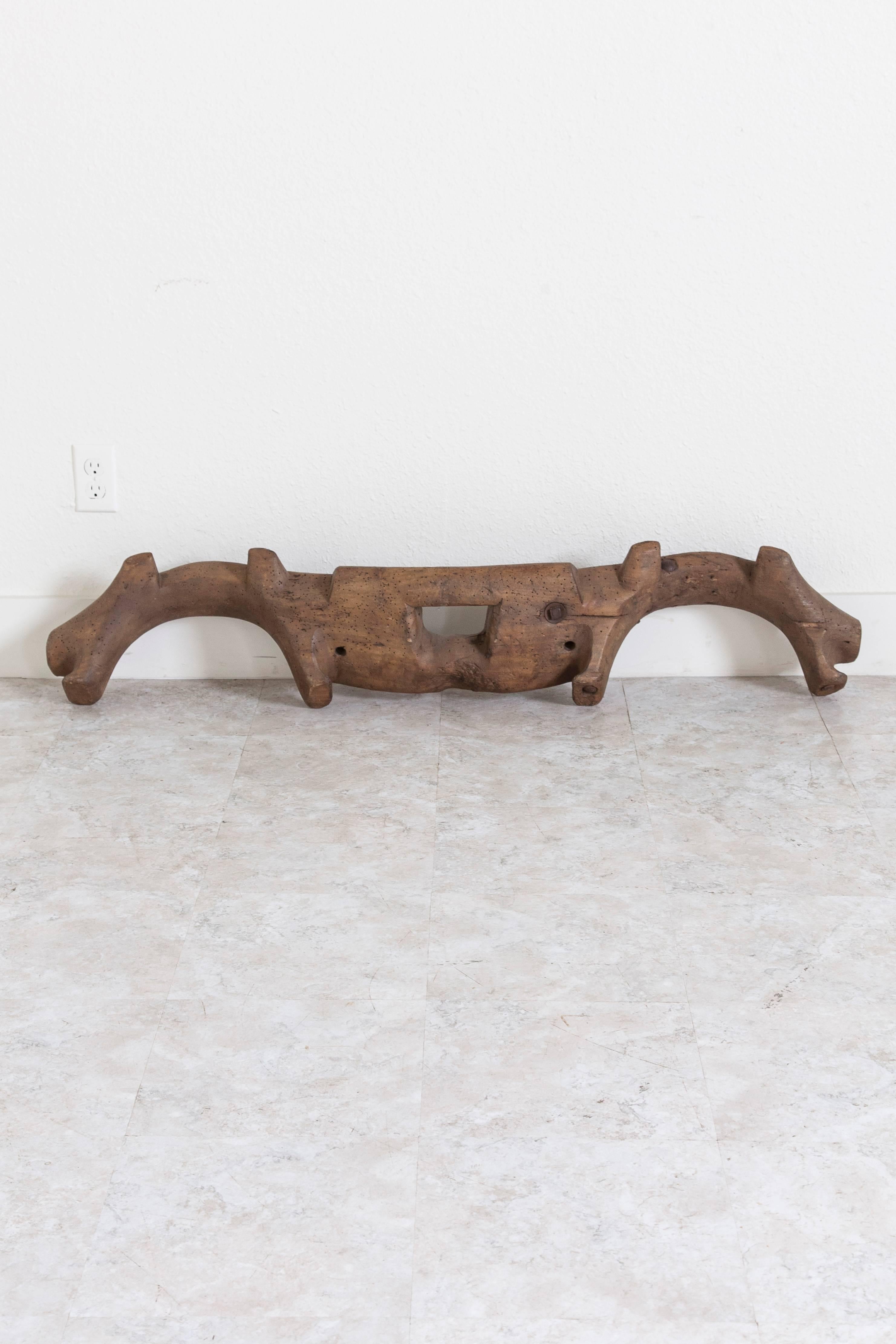 This rare handmade double oxen yoke was made from a single piece of wood in the mid-1800s in the Le Perche region of France. Created from beautifully aged wood with a rustic sculptural form, this yoke hangs easily from chain for display on a wall or