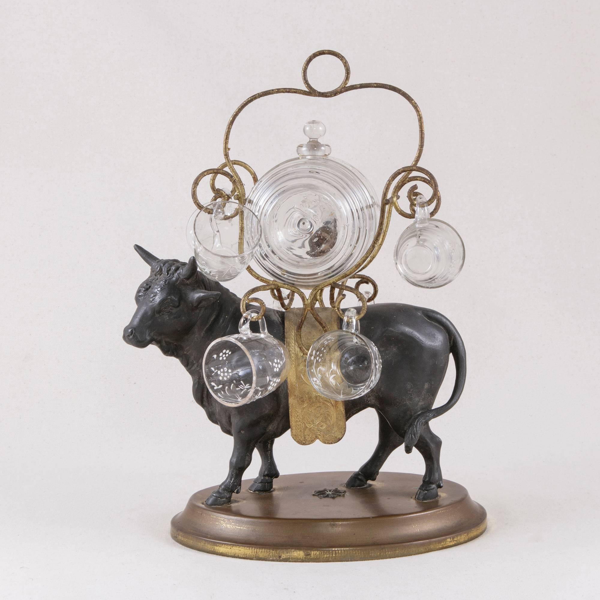 This mid-19th century Napoleon III cave a liqueur or liqueur caddy features a robust, bronze bull standing proudly on a brass base. His handsome gilt bronze saddle supports a hand-painted glass barrel with its original spigot and glass stopper and