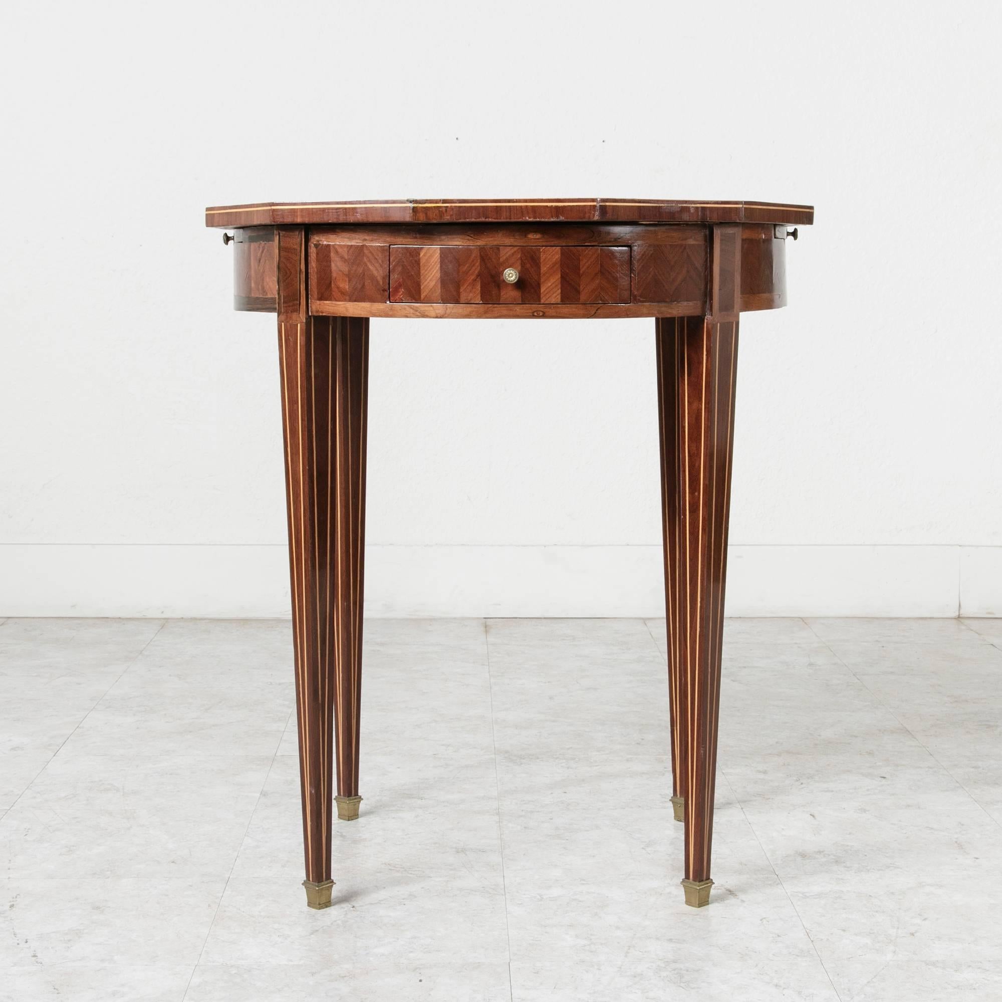 A nineteenth century Louis XVI style marquetry octagonal gueridon or table bouillotte with inlay including palisander, walnut, mahogany, and lemonwood. This nineteenth century version of the table bouillotte is named for the card game similar to