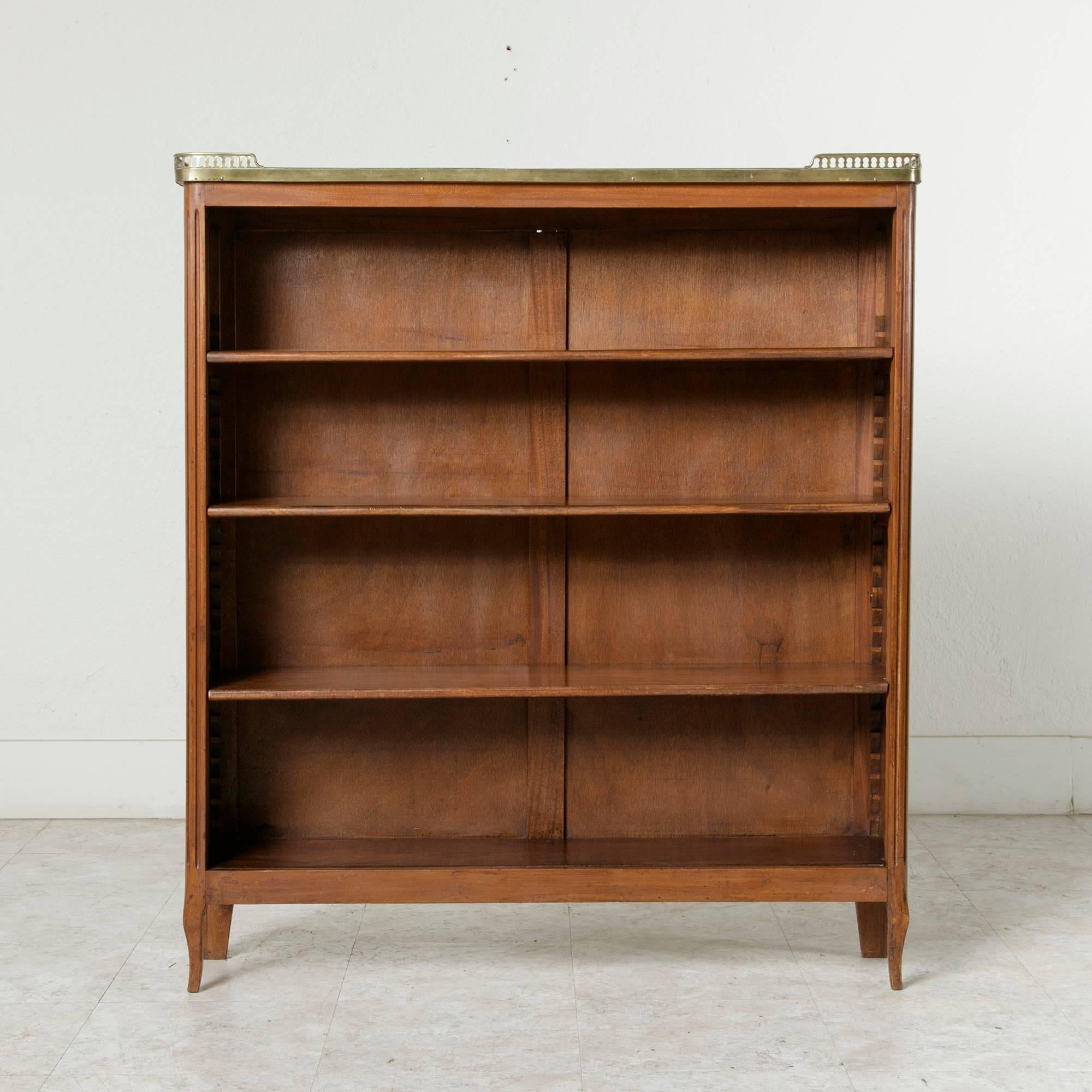 Found in the city of Versailles, this early 20th century French Louis XVI style mahogany bibliothèque or bookcase features three adjustable shelves and a grey marble top surrounded by a bronze gallery. Its narrow depth of 8.5 inches makes it a