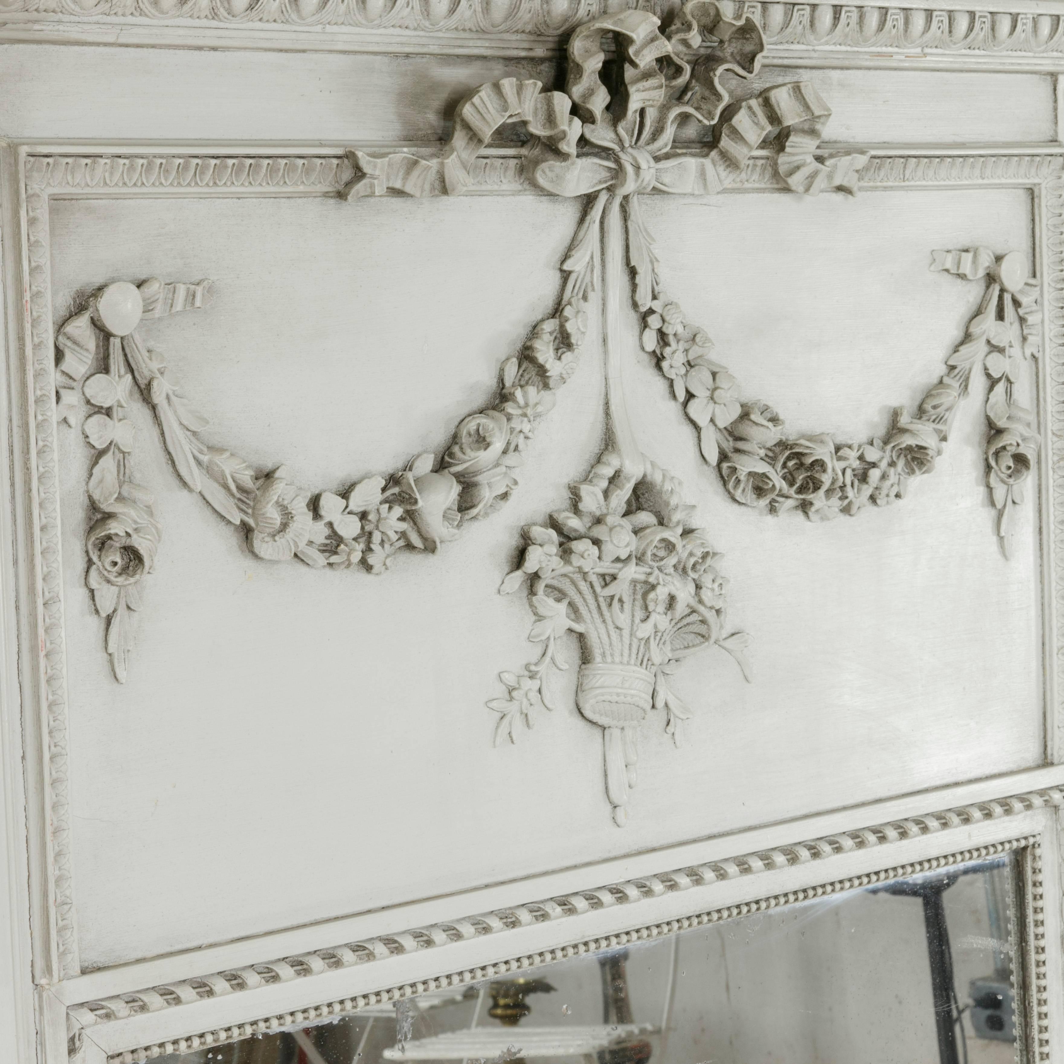 Painted in pale grey, this early twentieth century Louis XVI style trumeau mirror was originally part of a boiseries above the mantel of a French manor house. With beading and scrolled ribbon bordering its original mercury mirror, this piece