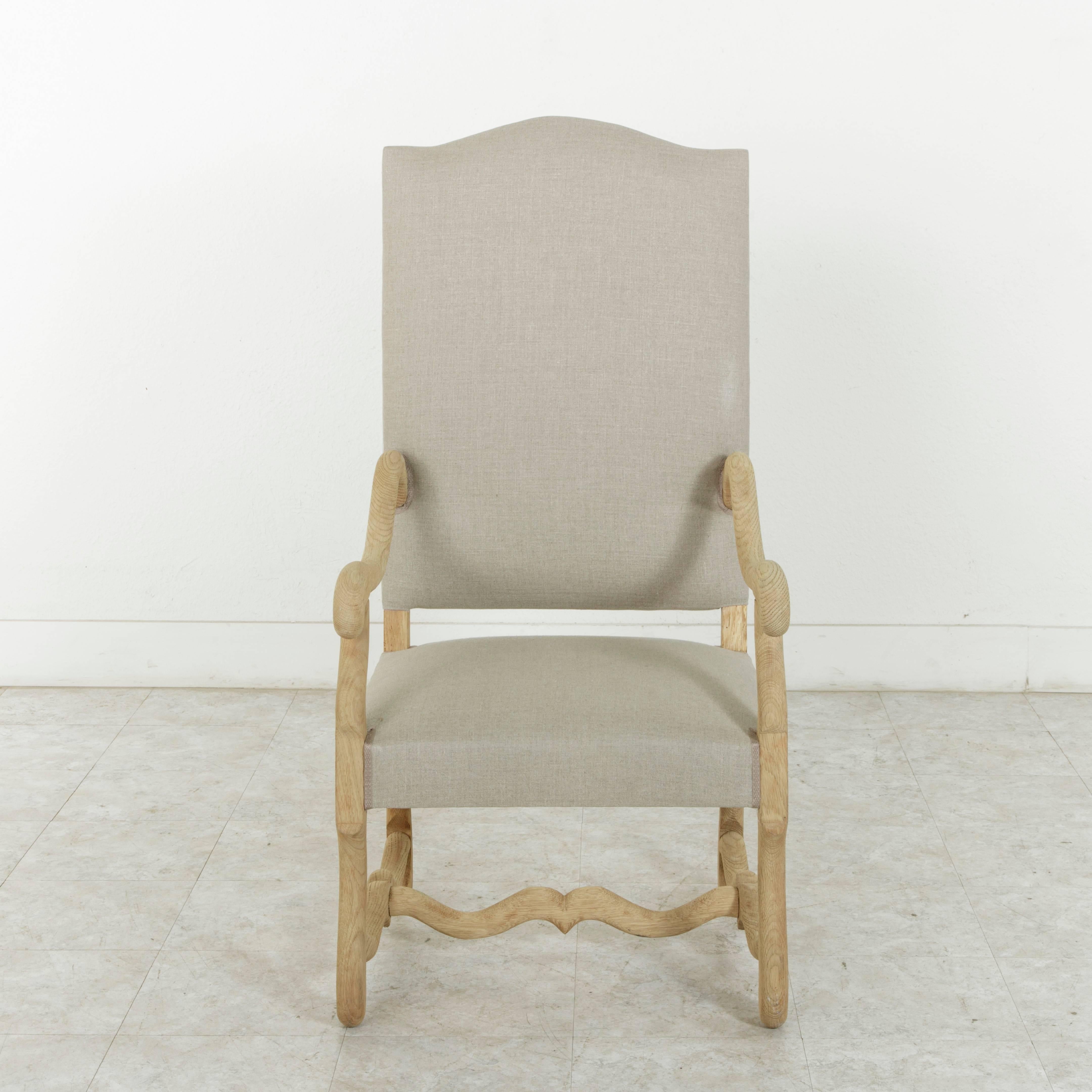 Newly upholstered in France in a beautiful neutral colored linen, this set of eight mutton leg dining chairs features six side chairs and two armchairs. The hand pegged, sturdy construction offers stability while the unfinished oak lend a light,