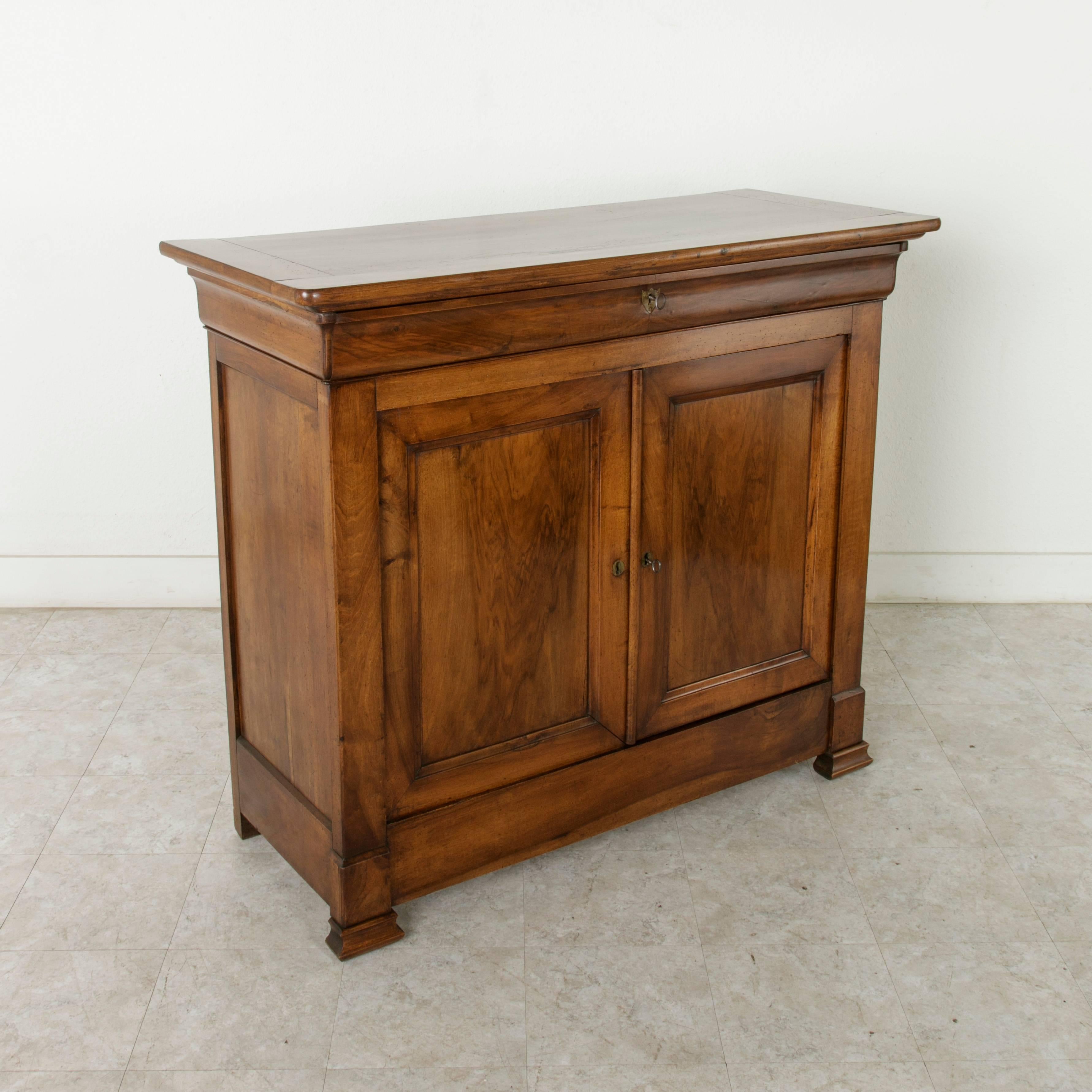 Known as a buffet d'appui in French due to its unusually tall height of 46 inches at which one can lean an elbow, this 19th century Louis Philippe period buffet is constructed of solid walnut. It features a single upper drawer and two lower doors
