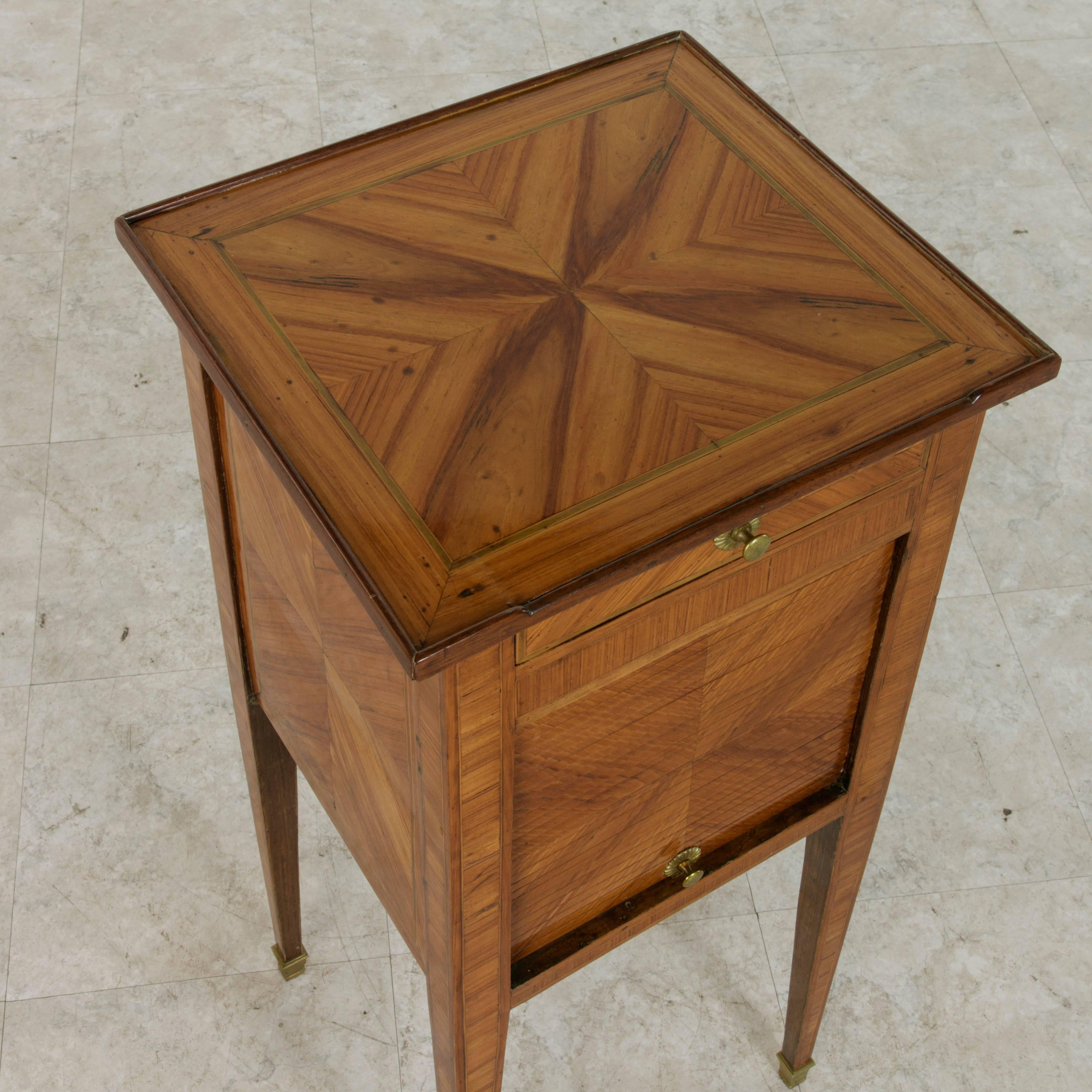 This eighteenth century Louis XVI period side table or nightstand is finished on all sides with exquisite book-matched rosewood marquetry detailed with fine lines of inlaid sycamore that frame the top and sides. Bronze sabots finish the tapered