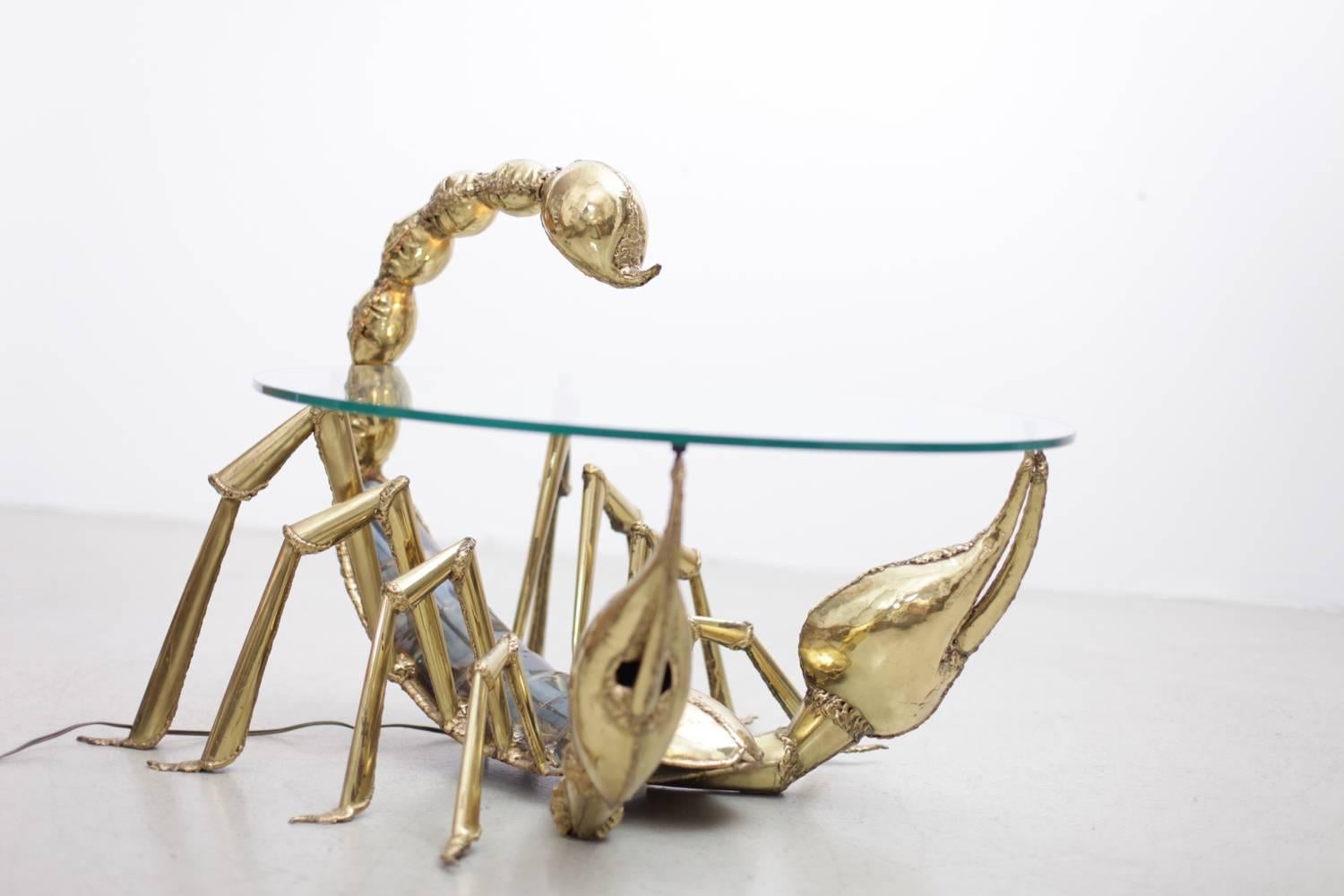 Very rare brass coffee or side table designed and produced by Jacques Duval-Brasseur in the 1970s. The table is made of brass and has a glass plate. The table is illuminated by a lamp integrated in the tail of the scorpion. One of a few ever