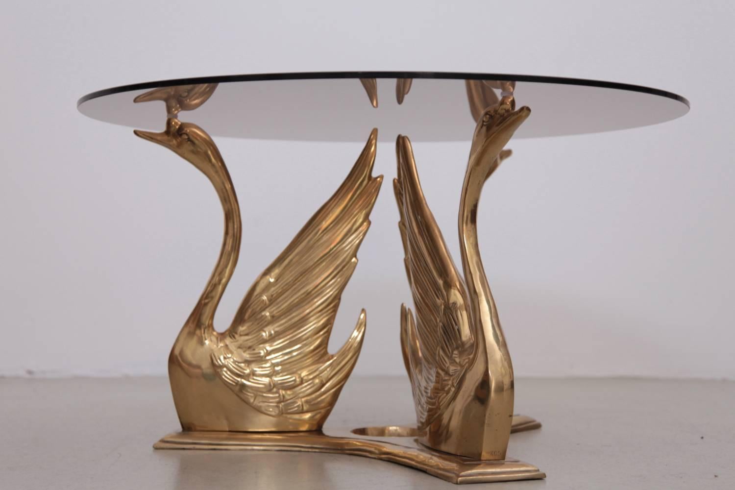 Very elegant coffee or side table in brass and glass. The glass table top is holded by swans. The table is a real eyecatcher.

