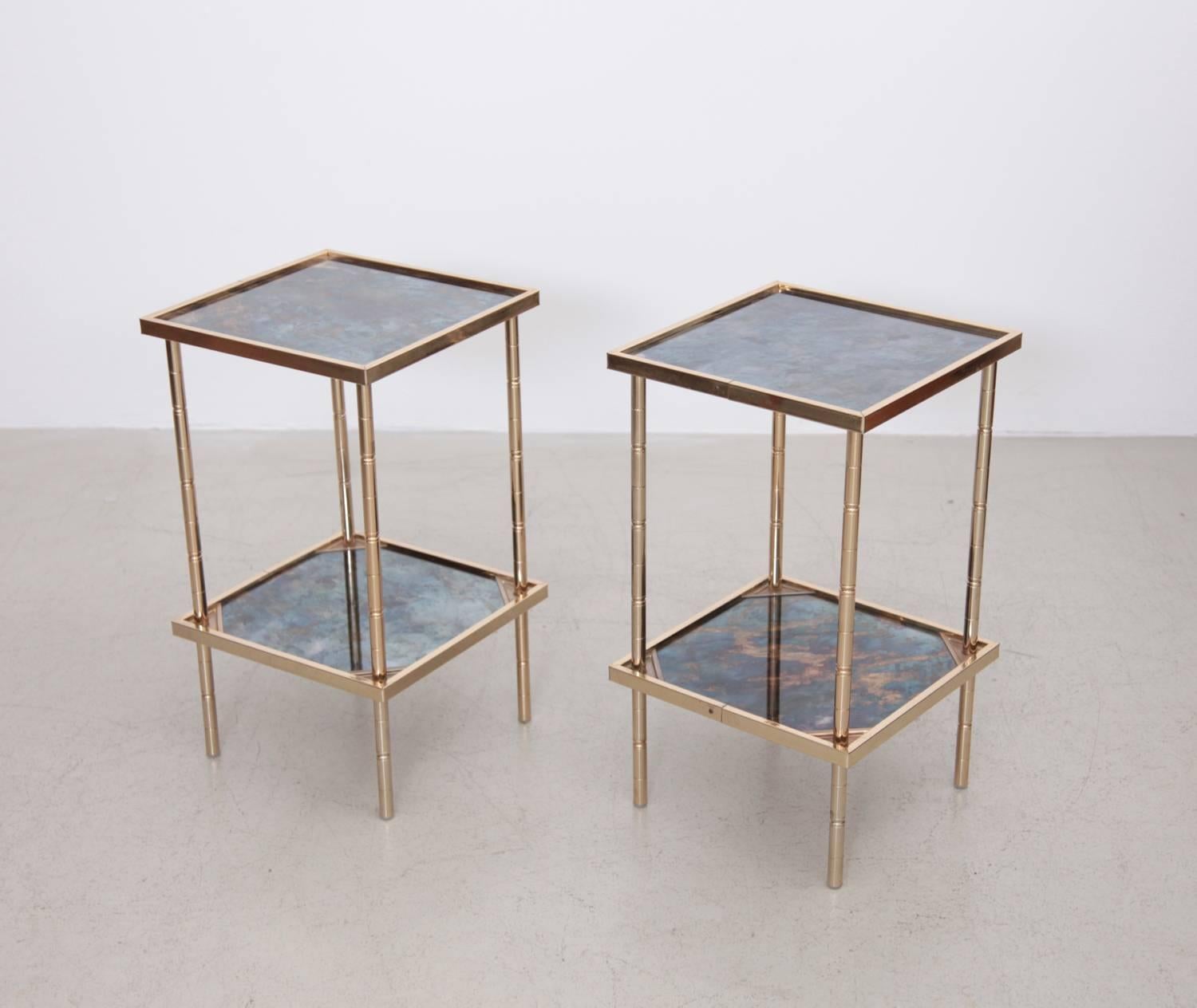 Wonderful pair of side tables or nightstands in brass with marbled glass. The tables are in excellent condition.