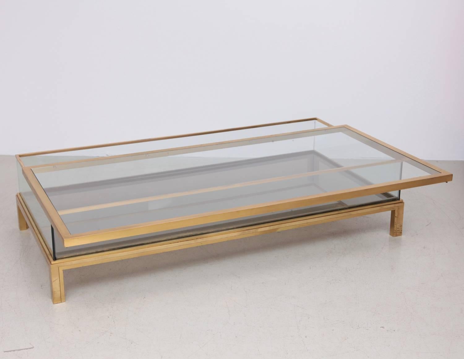 Spectacular huge glass table with sliding top by Maison Jansen. Frame has an total original gold-plated finish. One of a kind table in this size. The glass has some chips on the edges and one on top (see photos).The Table slides to both sides. If