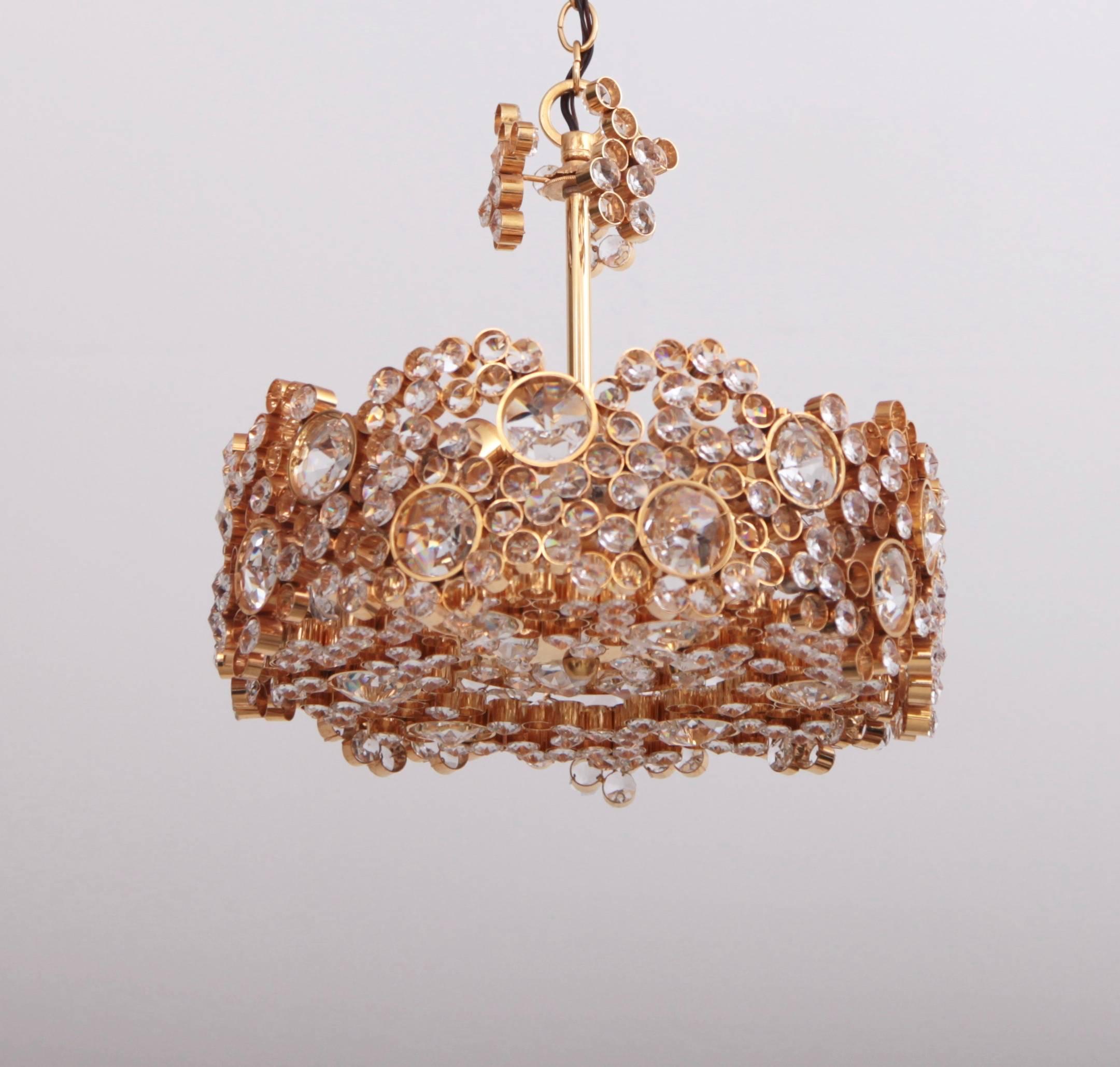 Outstanding chandelier from the 1960s by German high end crystal glass manufacturer Palwa. The 24-carat gold-plated brass frame is encrusted with hundreds of high quality diamond like crystals. The chandelier is handmade, in excellent condition and