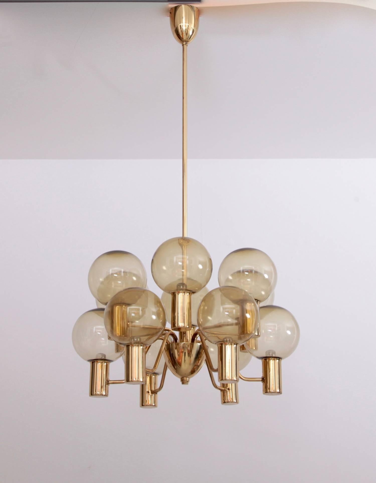 Chandelier with twelve-light sources, featuring a brass frame and smoked glass. It was designed by Hans-Agne Jakobsson and manufactured by Markaryd, Sweden, 1960s.