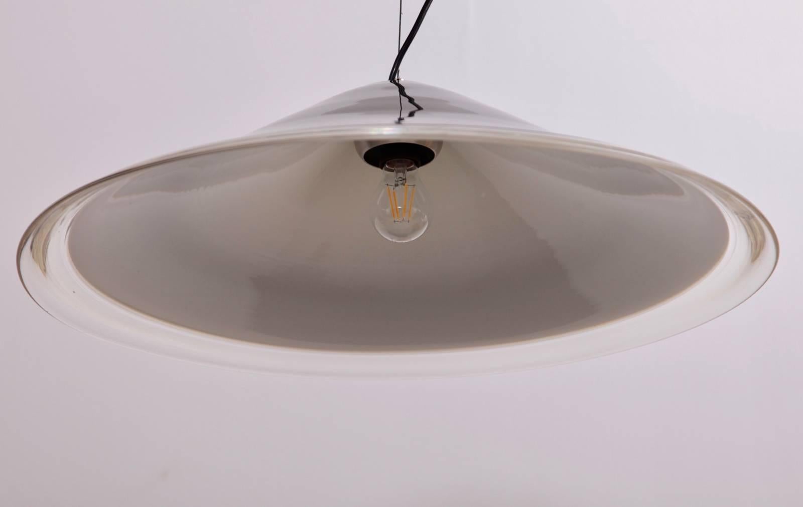 This Melaina ceiling lamp was designed by Renato Toso and was produced by Leucos in 1968. It has a thick glass cone lampshade, with a black exterior, white interior and a transparent ring around the end. It is possible to adjust the angle of the