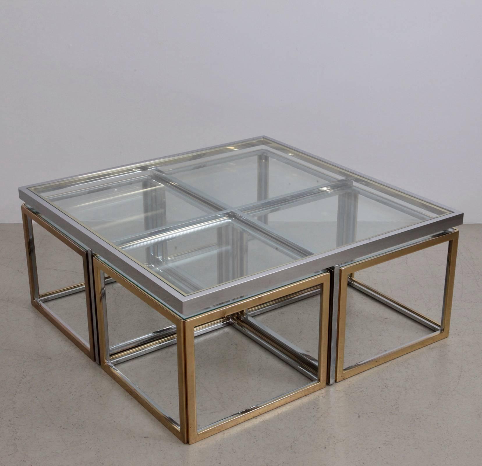 Beautiful coffee table with four nesting tables in brass and chrome by Maison Charles. The glass plates are loosely inserted to create the table surfaces. The table is in very good condition.

