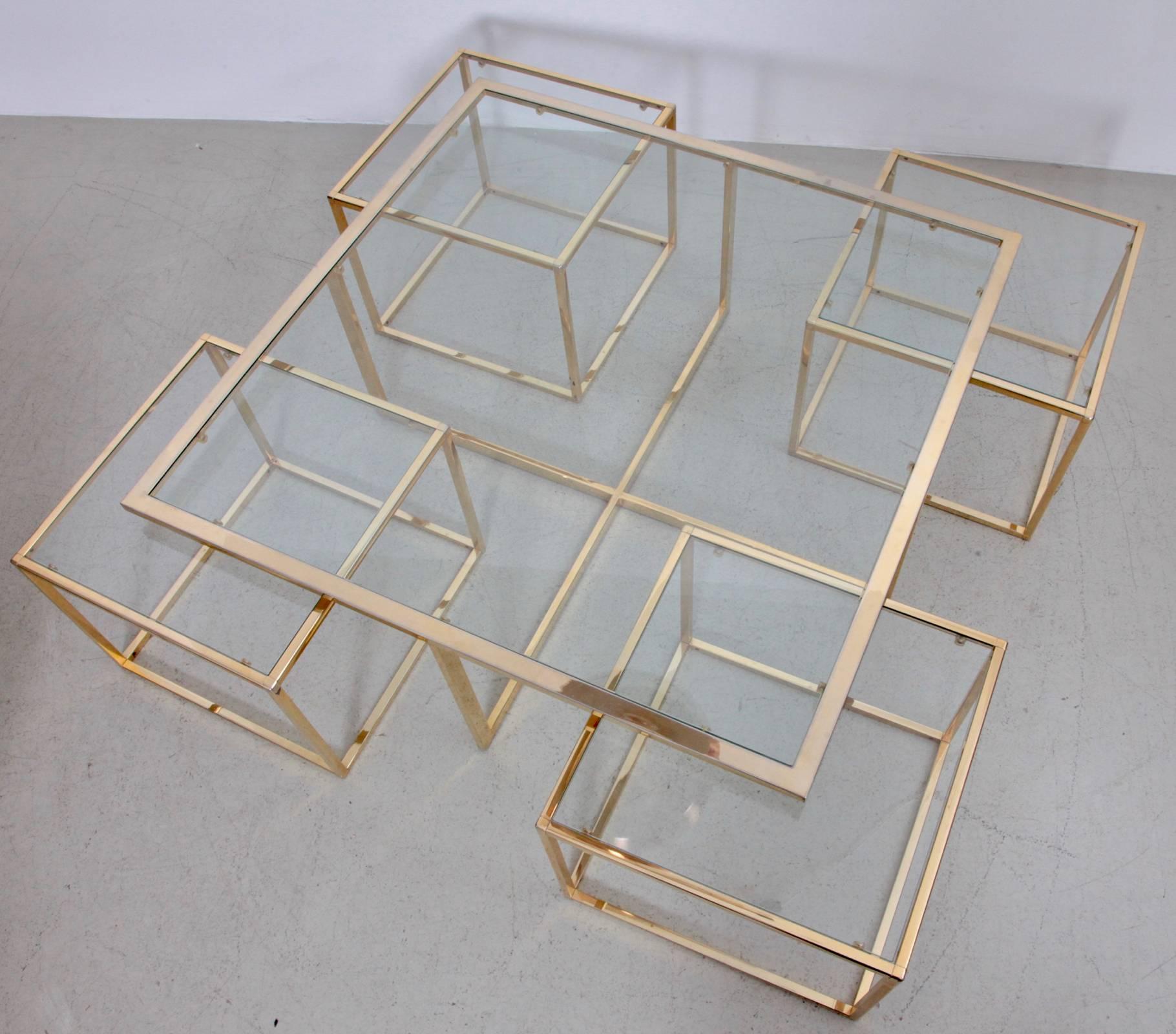 Beautiful coffee table with four nesting tables in brass by Maison Charles. The glass plates are loosely inserted to create the table surfaces. The table is in very good condition.

