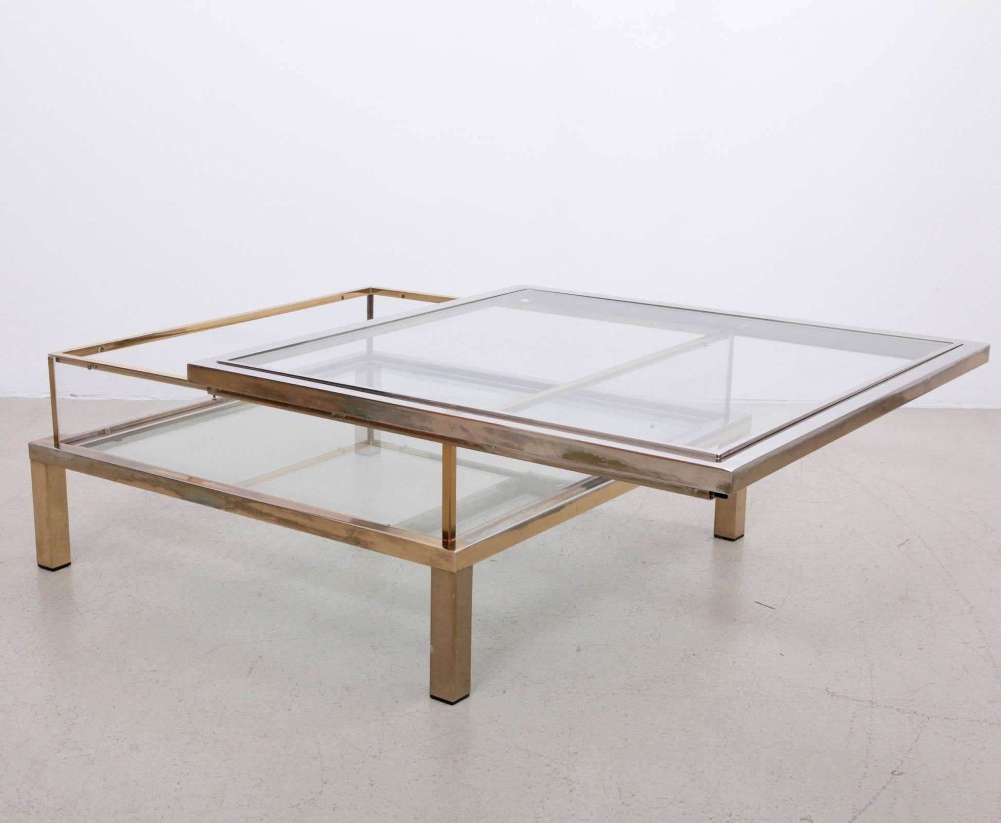 Großer quadratischer Glastisch mit Schiebeplatte von Maison Jansen. Der Rahmen ist aus vergoldetem und verchromtem Metall gefertigt. Der Tisch weist eine schöne Patina auf.

