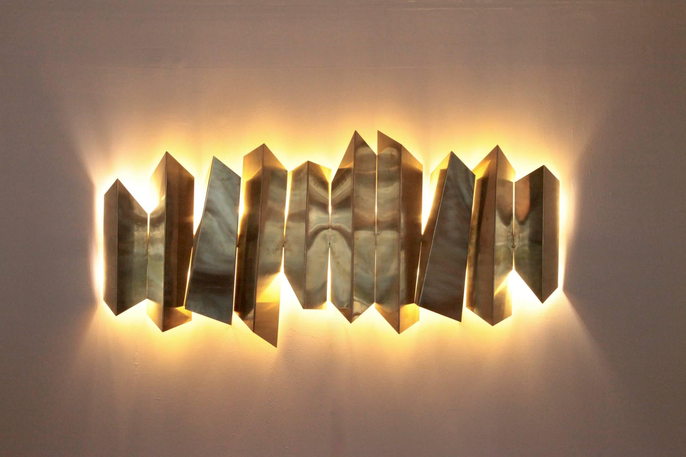 Huge illuminated brass wall sculpture lamp attributed to Mario Torregiani. The wall lamp has a impressive size and will bring glamour in each room. 20 x E14.

