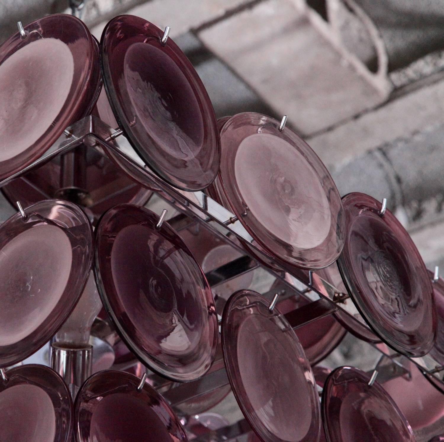 Merveilleux grand lustre à disques en verre de Murano de couleur améthyste attribué à Vistosi.
Le lustre est un accroche-regard coloré dans chaque pièce.

Pour plus de sécurité, la lampe doit être contrôlée localement par un spécialiste des