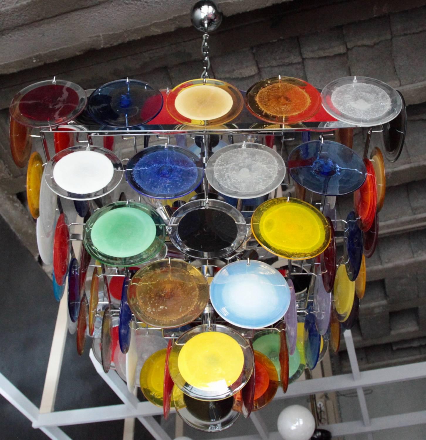 Monumental large multi-color Murano glass disc chandelier by Vistosi. The chandelier is a colorful eye catcher in every room. A smaller, but even large one of these chandeliers is also listed. 8xE27/Model a Bulbs.

To be on the the safe side, the