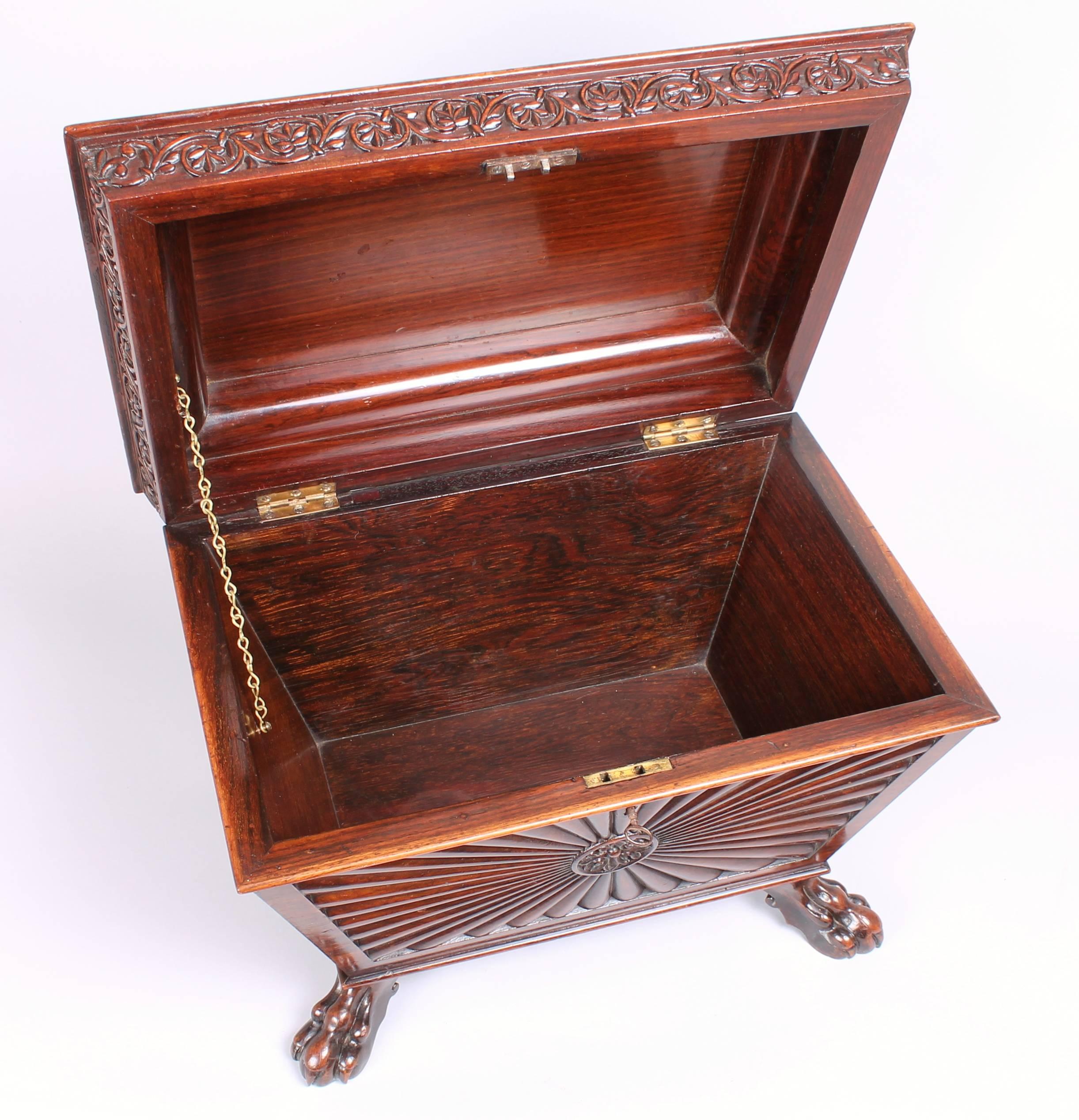 George IV period solid rosewood casket in the Anglo-Indian manner; boldly carved with reeded sunburst panels and a frieze of scrolling foliate trails, on claw feet.