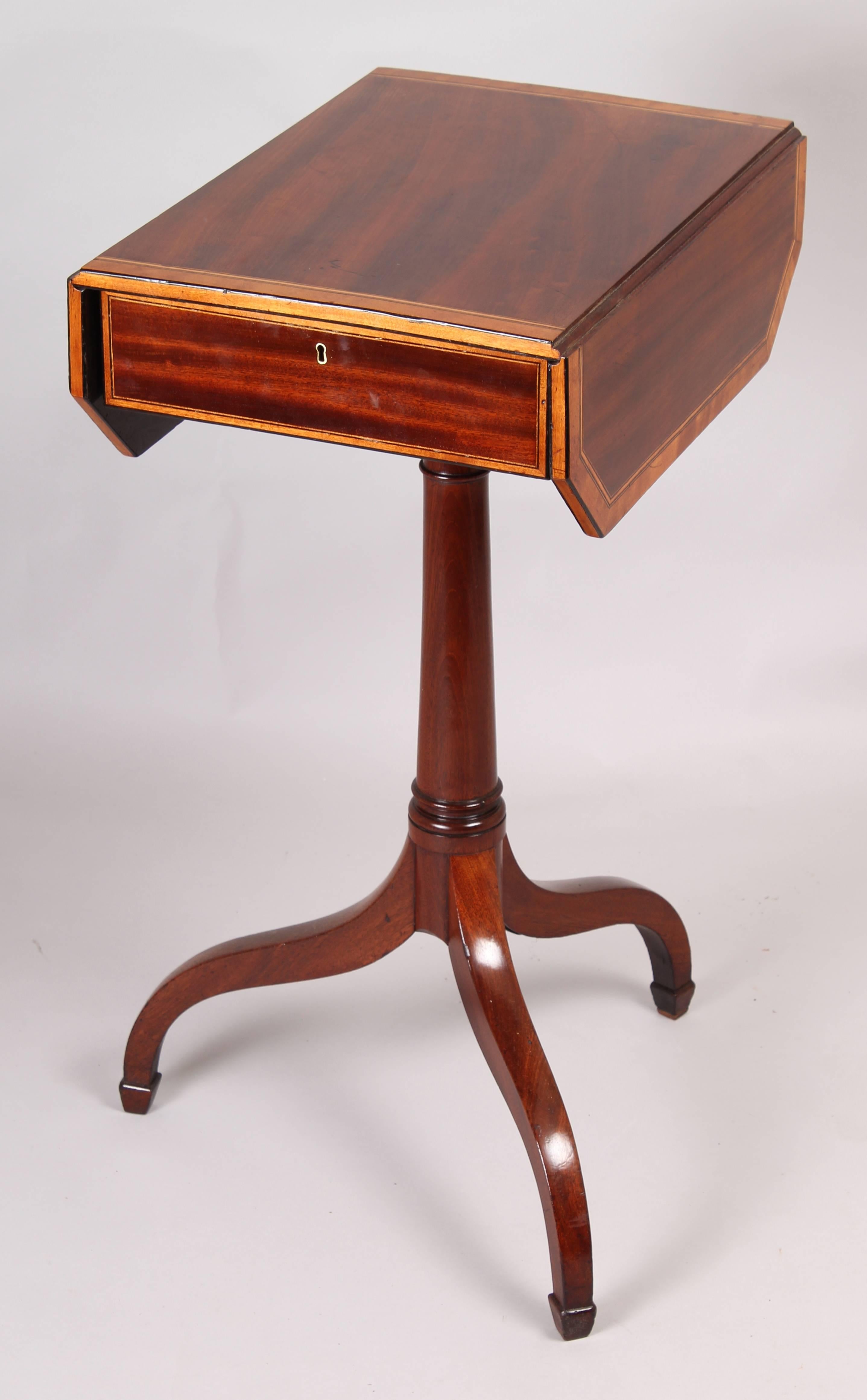 George III period mahogany small Pembroke work-table; the drop-leaf top with angled corners and satinwood banded edges, fitted with a cedar-lined drawer and on a simple turned shaft and a crabstock tripod base, circa 1800.