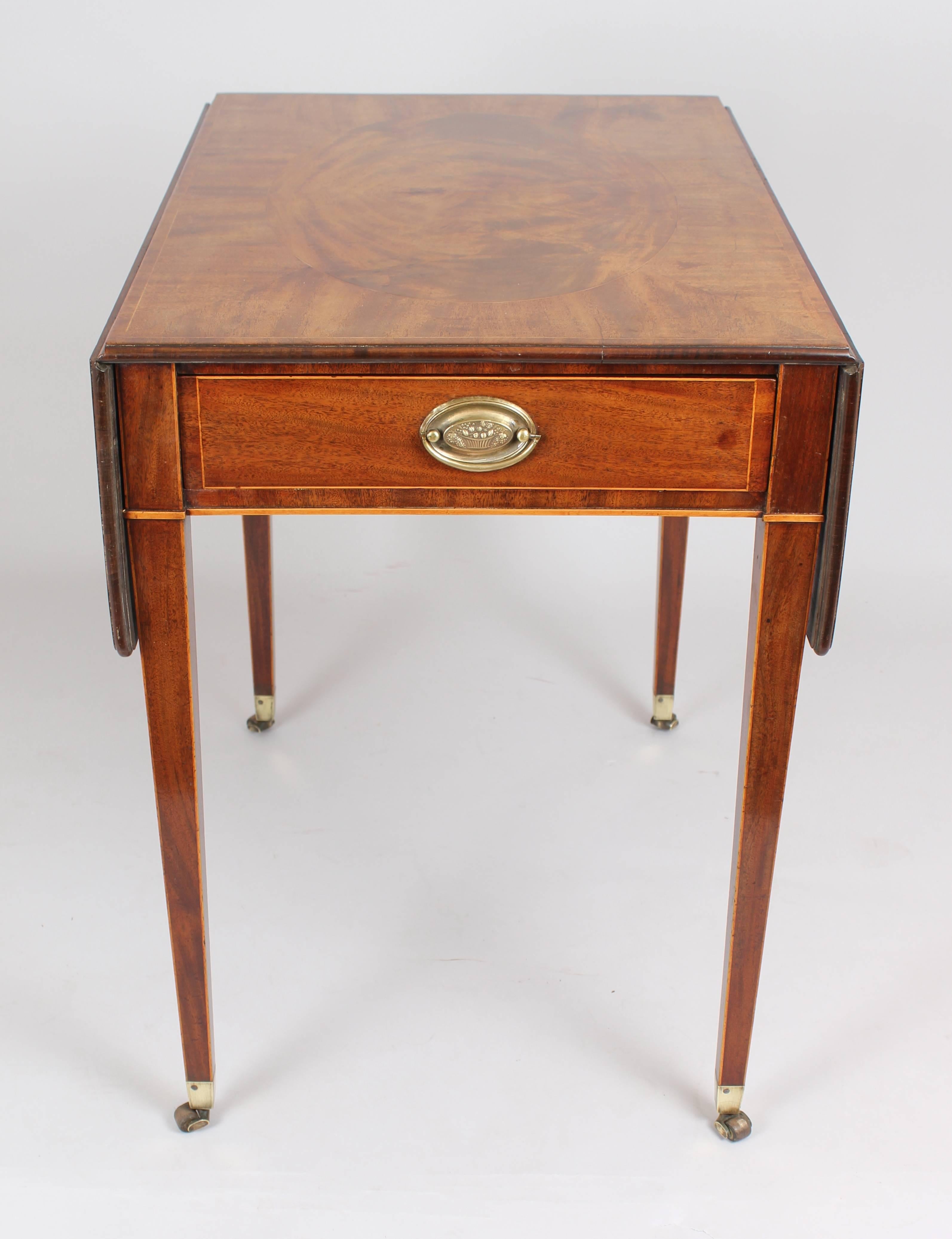Fine George III period mahogany Pembroke table; the top and leaves each inlaid with an oval pair-veneered panel on a diagonally-veneered ground; fitted with two drawers with later brass oval-plate handles, on square legs with original brass