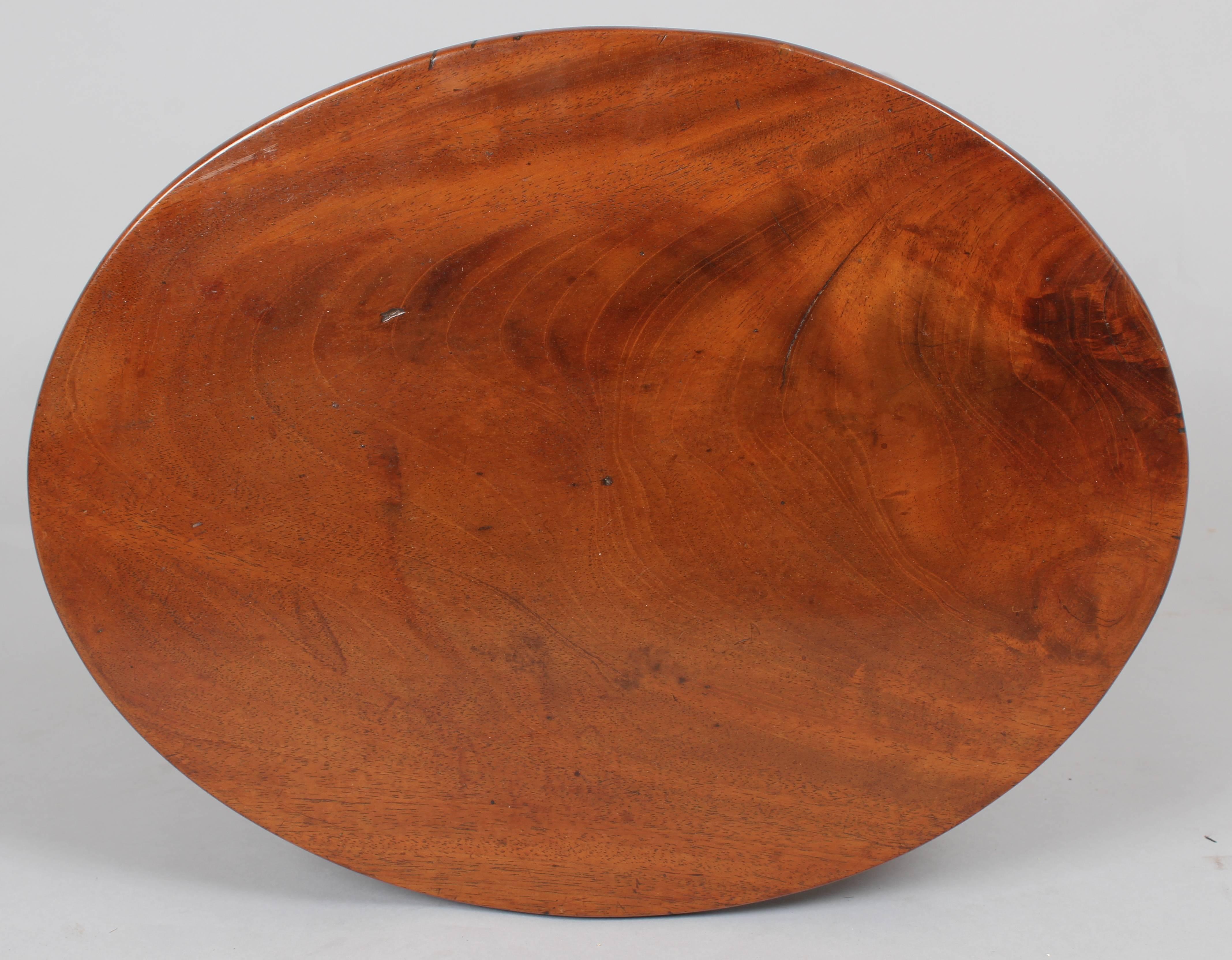 A simple George III period mahogany stool with an oval top and splayed tapering legs.