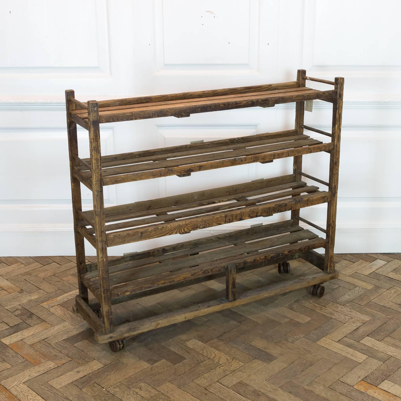 A rustic reclaimed pine shoe rack of French origin.