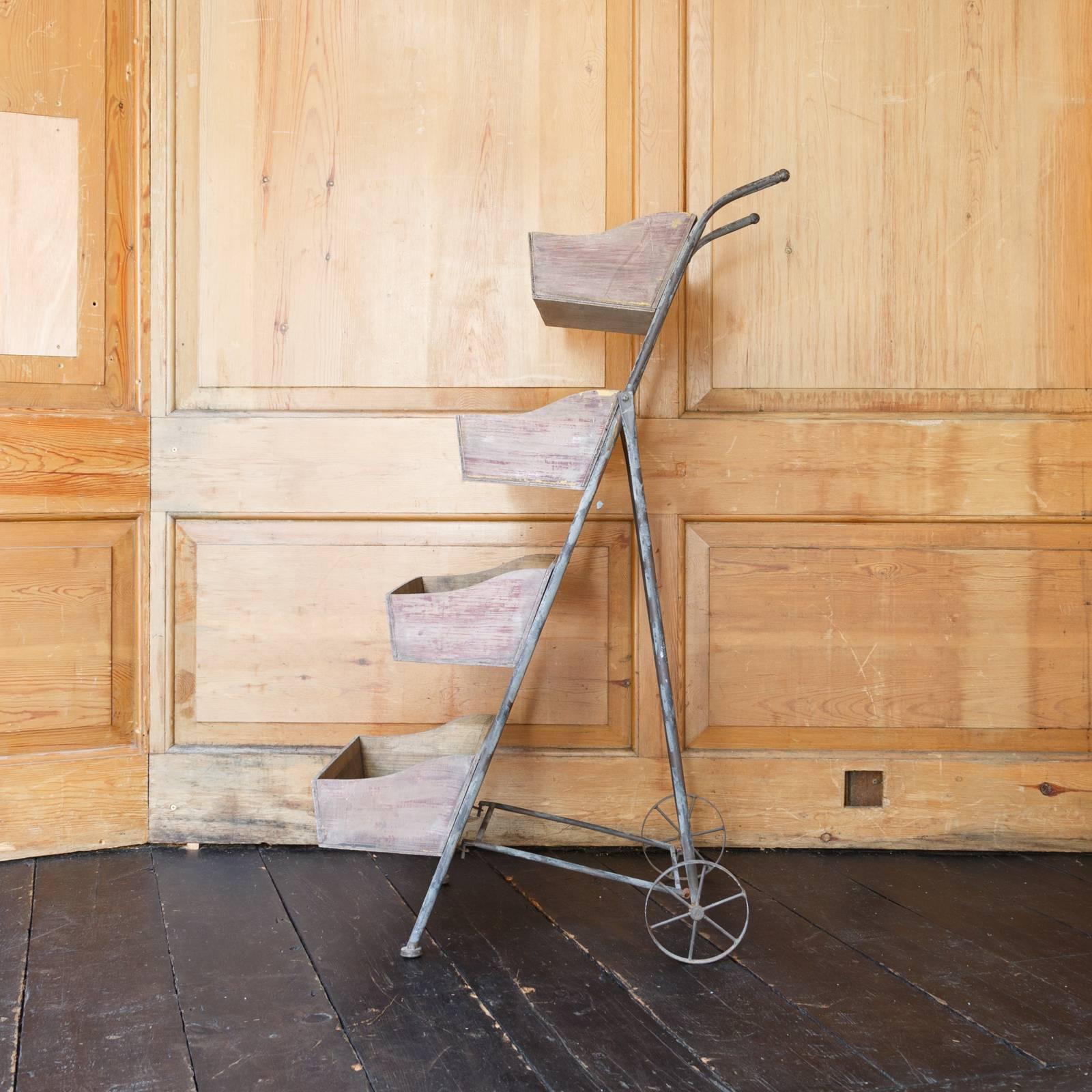 A four-tier pine and steel French grocers trolley on castors.