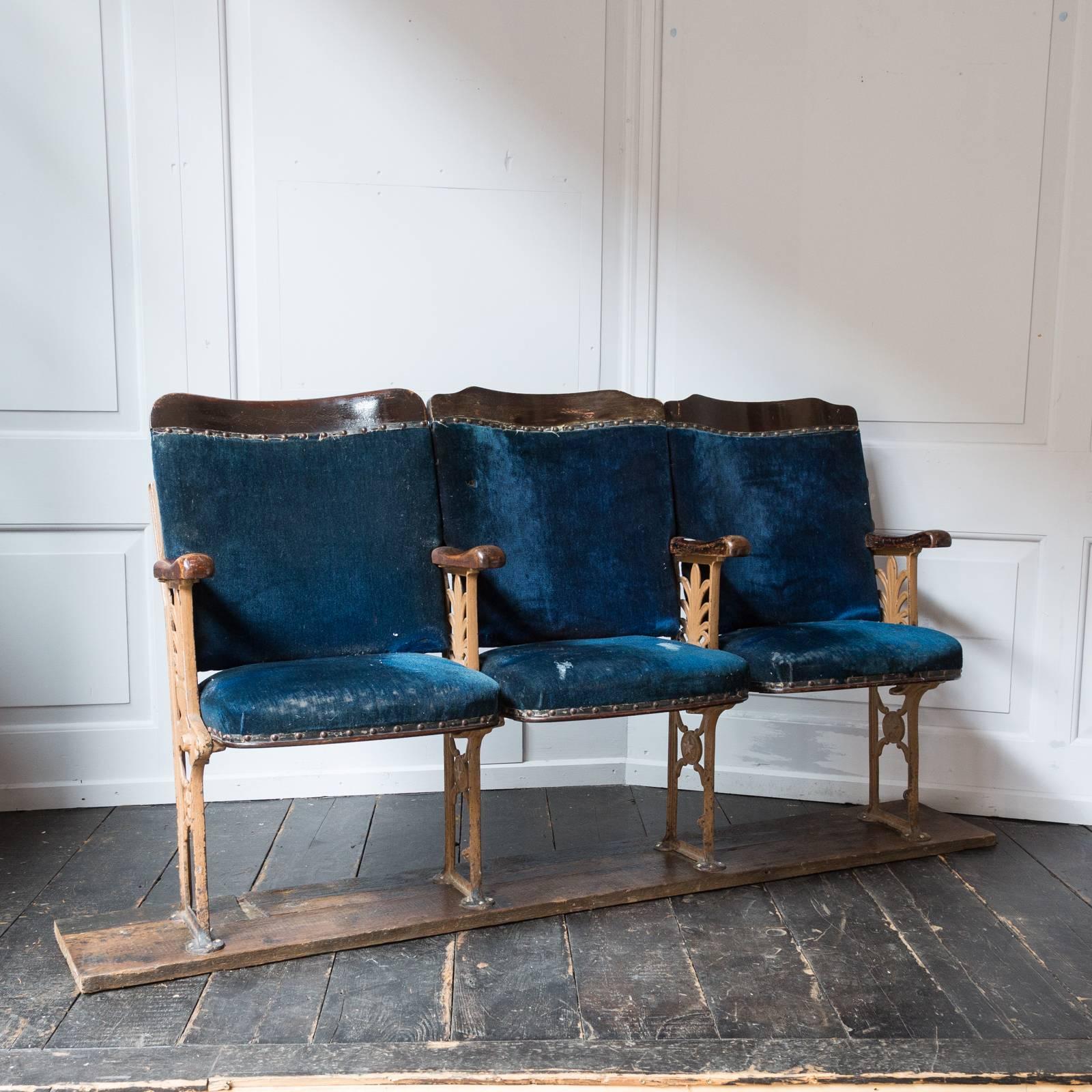 Ex Curtain Road, Shoreditch, London. A triplet of distressed Victorian velvet cinema seats with highly ornate cast iron supports and later dark stained pine base.