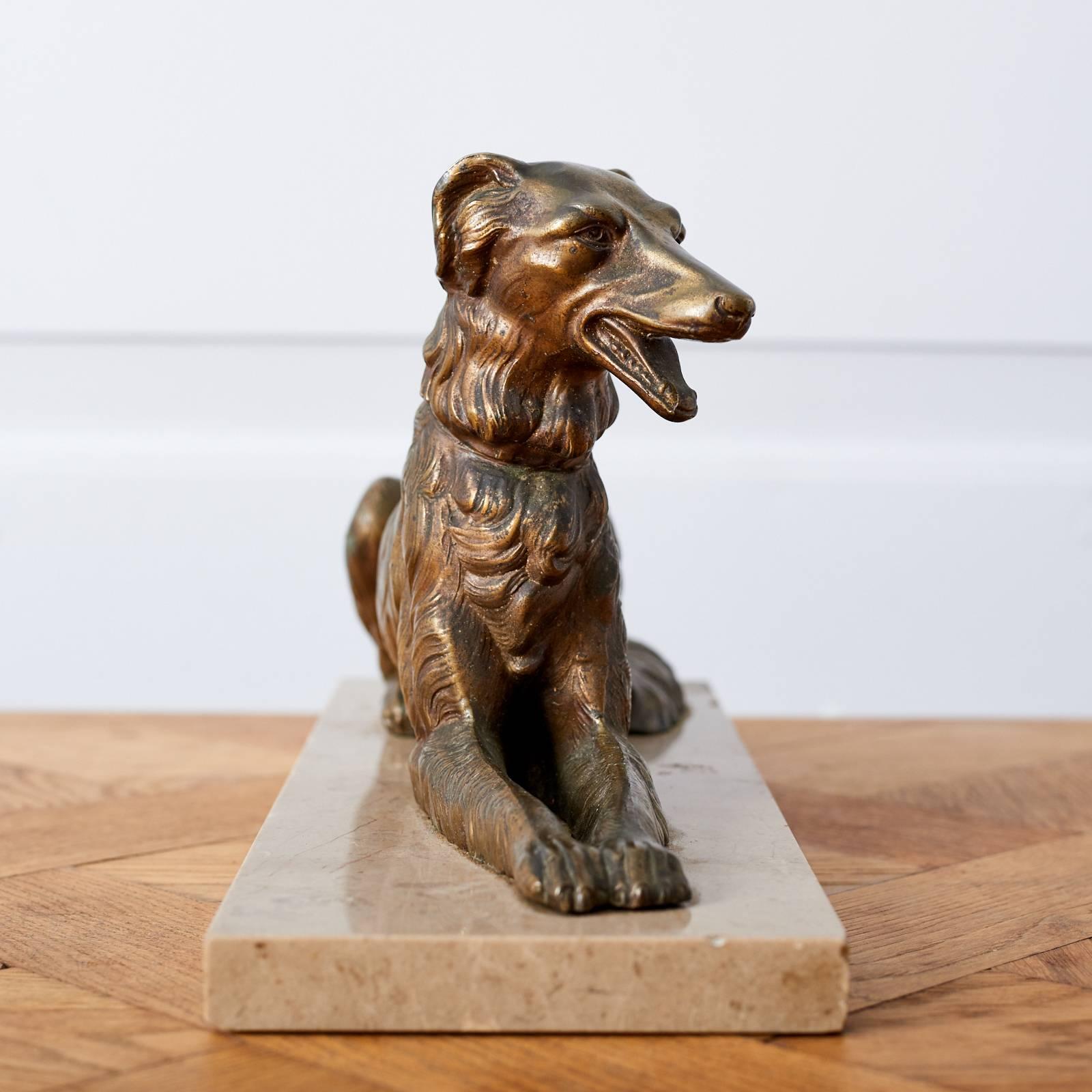 A cast bronze statuette of an English Lurcher on a pink marble base.
 