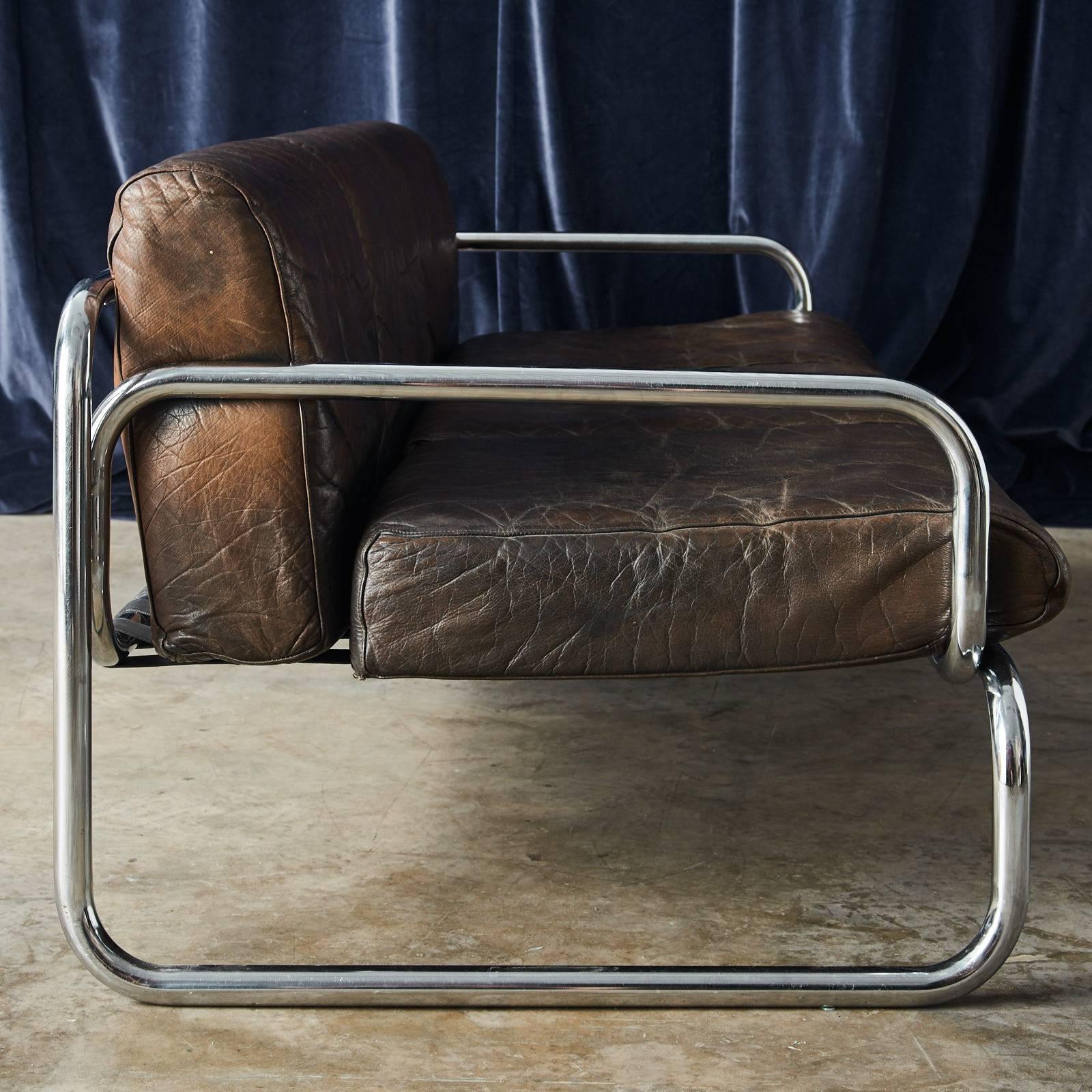 A Rodney Kinsman for OMK sofa, circa 1969, three-seat with black hide seat and back cushions, with tubular steel frame.