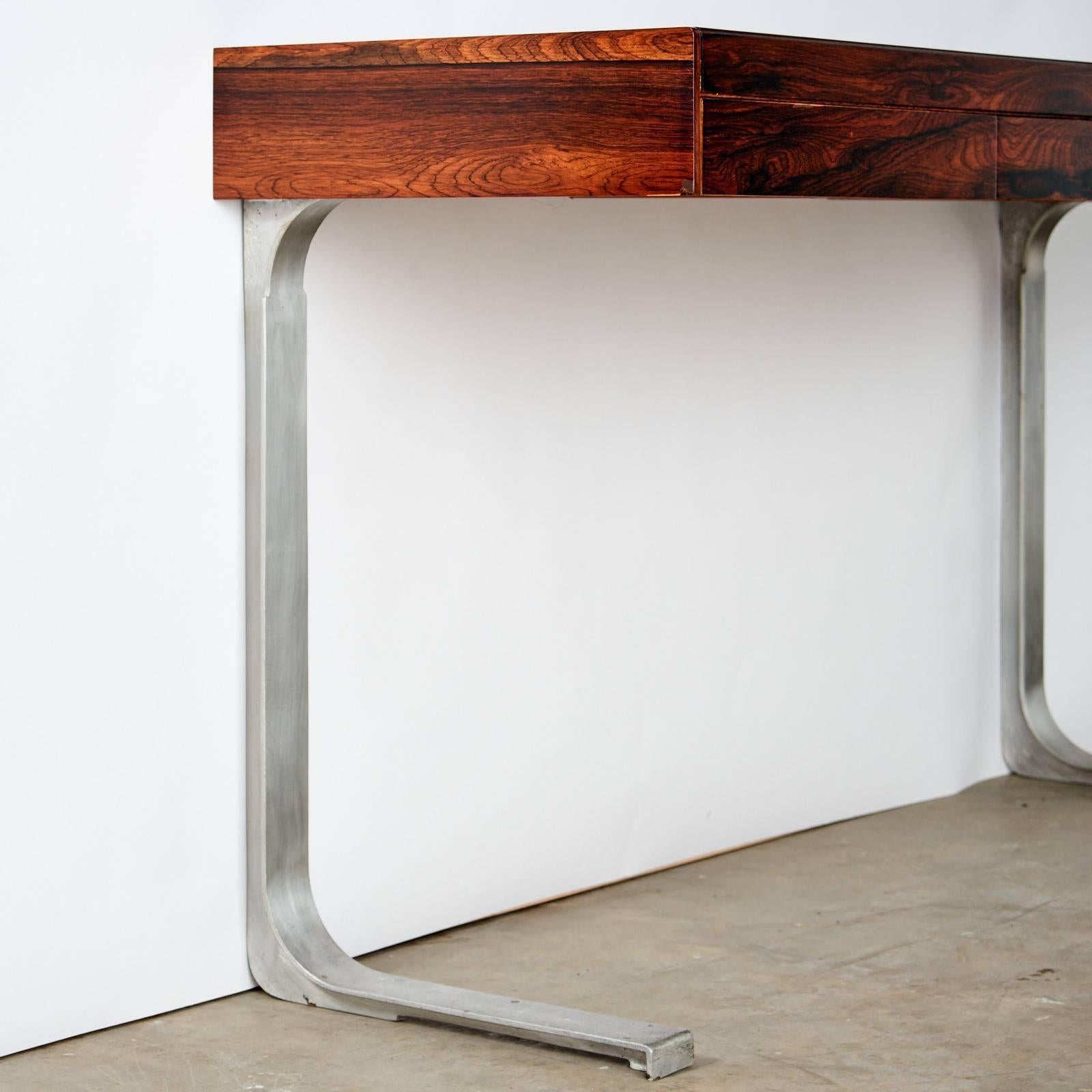 A rosewood console table with three drawers including felt lined cutlery drawer on cast aluminium legs. Designed by Robert Heritage, manufactured by Archie Shine, as part of the 'Planar' series, circa 1967.