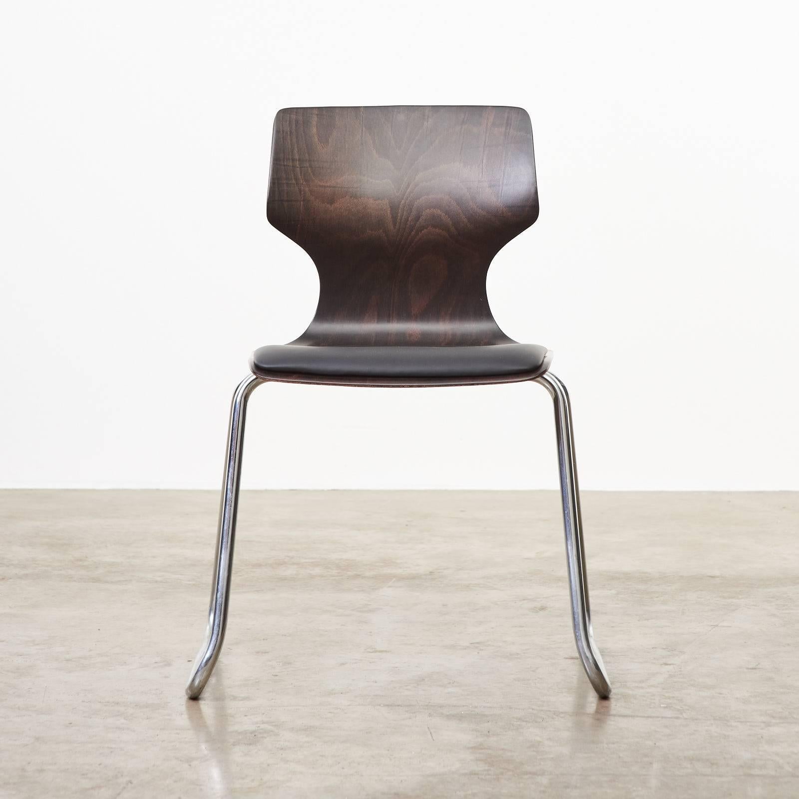 A Mid-Century West German stackable dining chair produced by the Flötotto company in the 1950s. The black Italian leather reupholstered cushion on ply 'pagwood' seat above the tubular chrome base frame. Multiples available.