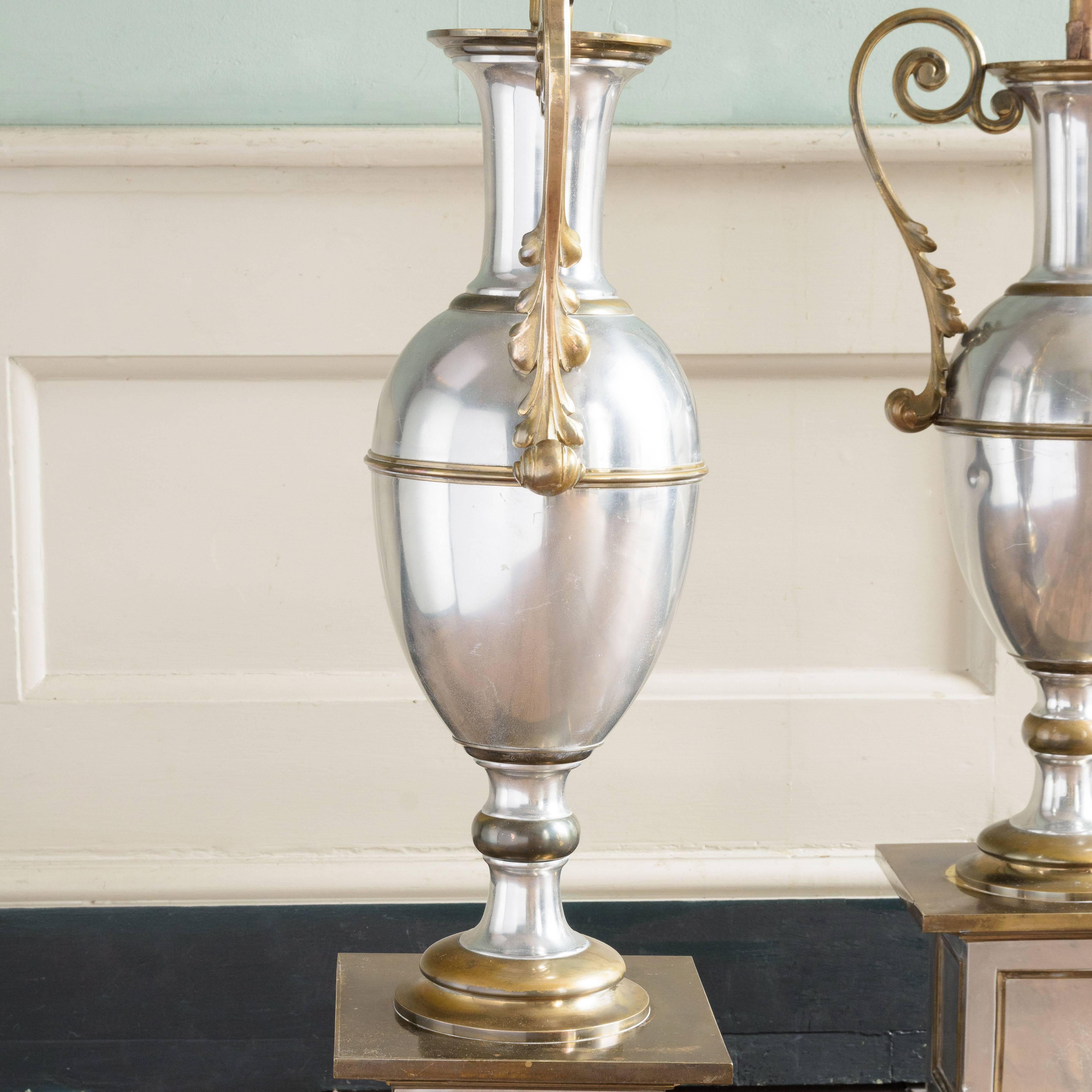 A unique pair of 1970s French floor lamps, in the manner of Maison Charles, each gilt metal five light foliate plume issuing from classical twin-handled urn on pedestal base.