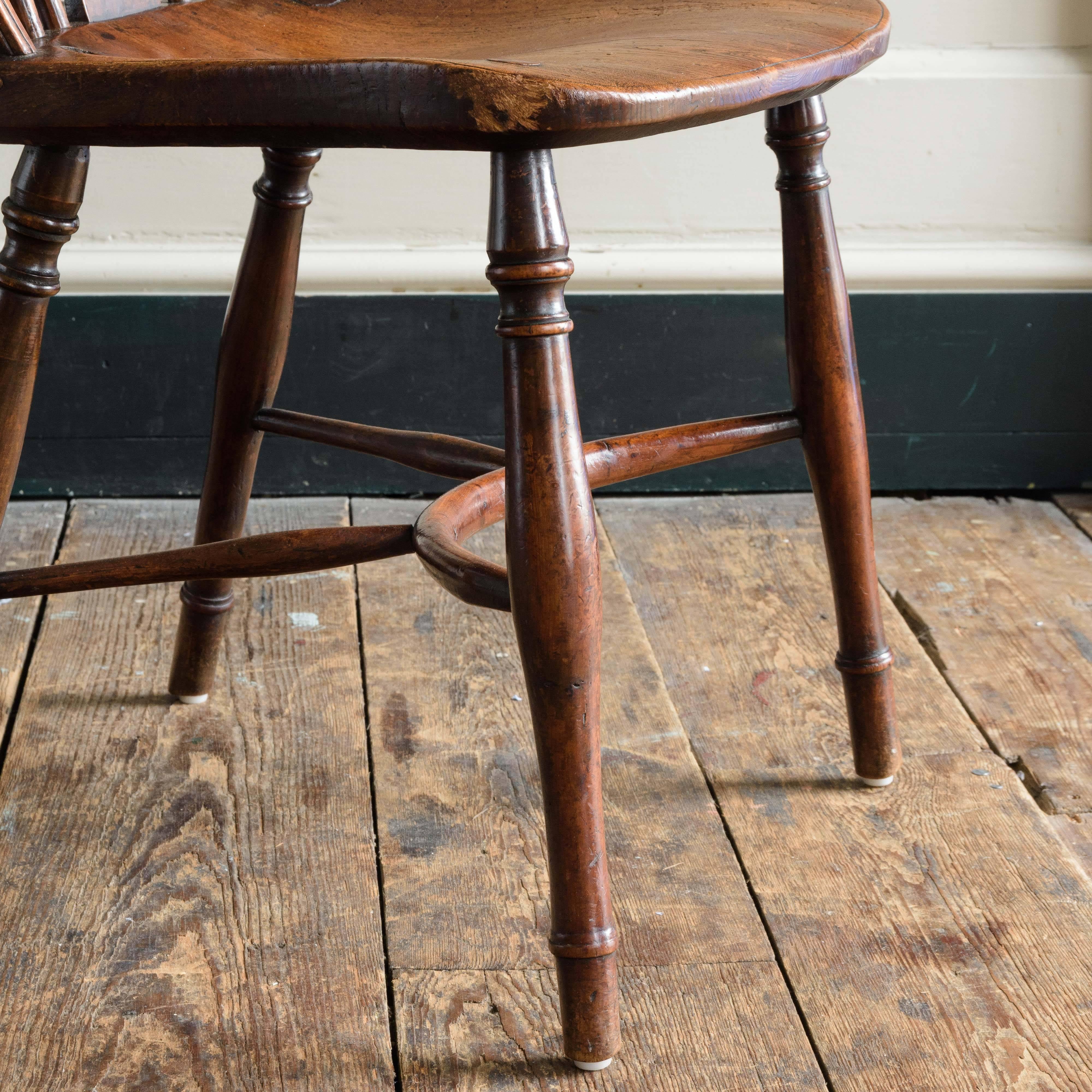 Matched set of seven Buckinghamshire wheel-back Windsor chairs, including two armchairs, yew with well-saddled elm seats, some historic replacement turned parts in ash and beech.

Standard chairs are 90.5 cm high, 43 cm wide, 45 cm depth.