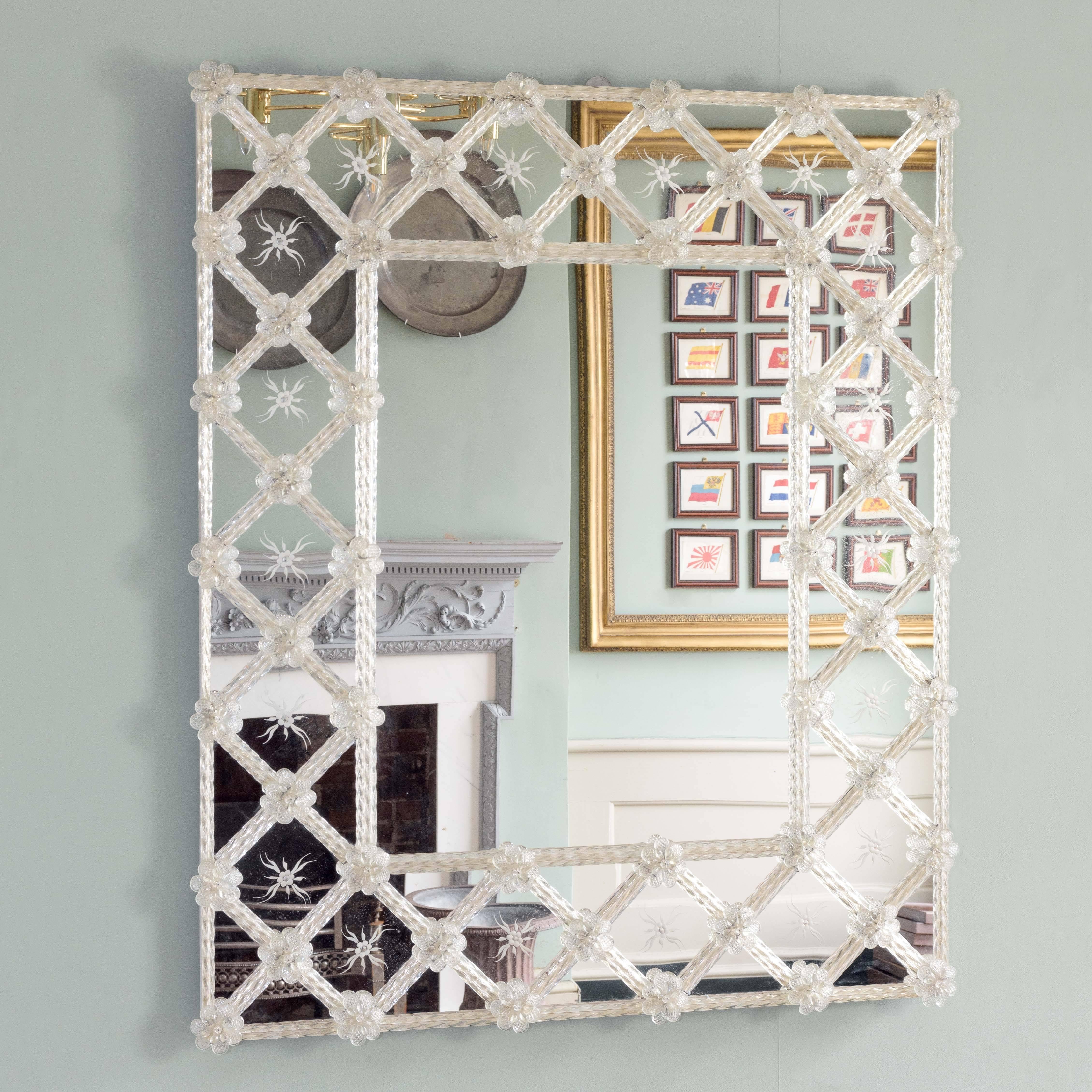 1970s Italian wall mirror, with moulded glass crosshatched frame and floral bosses to the intersections.