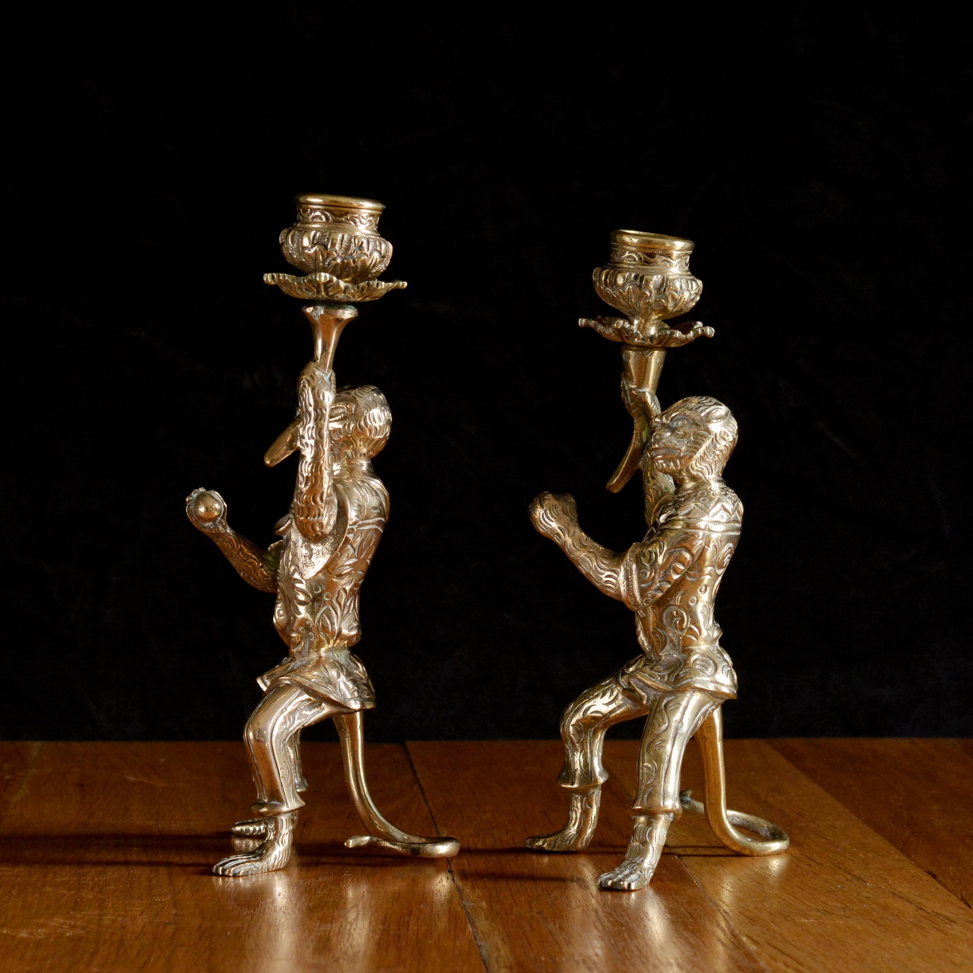 A pair of late 19th century bronze monkey candlesticks, possibly Italian, each holding aloft torches, each monkey dressed in jester outfit in seated position supported by tail.

Available to view at Brunswick House.

Measures: 22.5cm (8¾