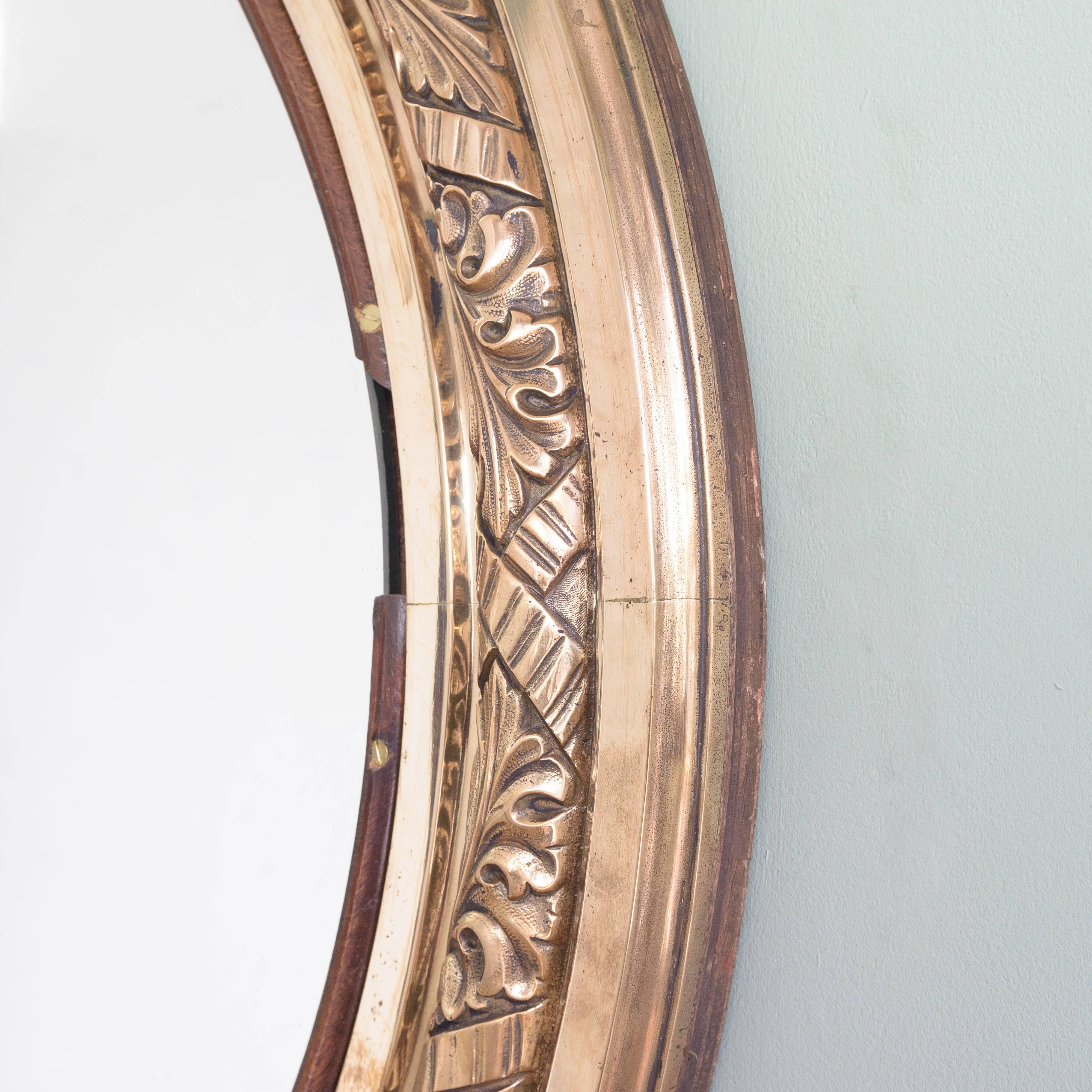 Pair of early 20th century bronze oval mirrors, by repute from R.M.S. Olympic, the frames with floral and rope-twist detailing, one with original bevelled plate the other a replacement, circa 1910. Can be hung portrait or landscape.

 