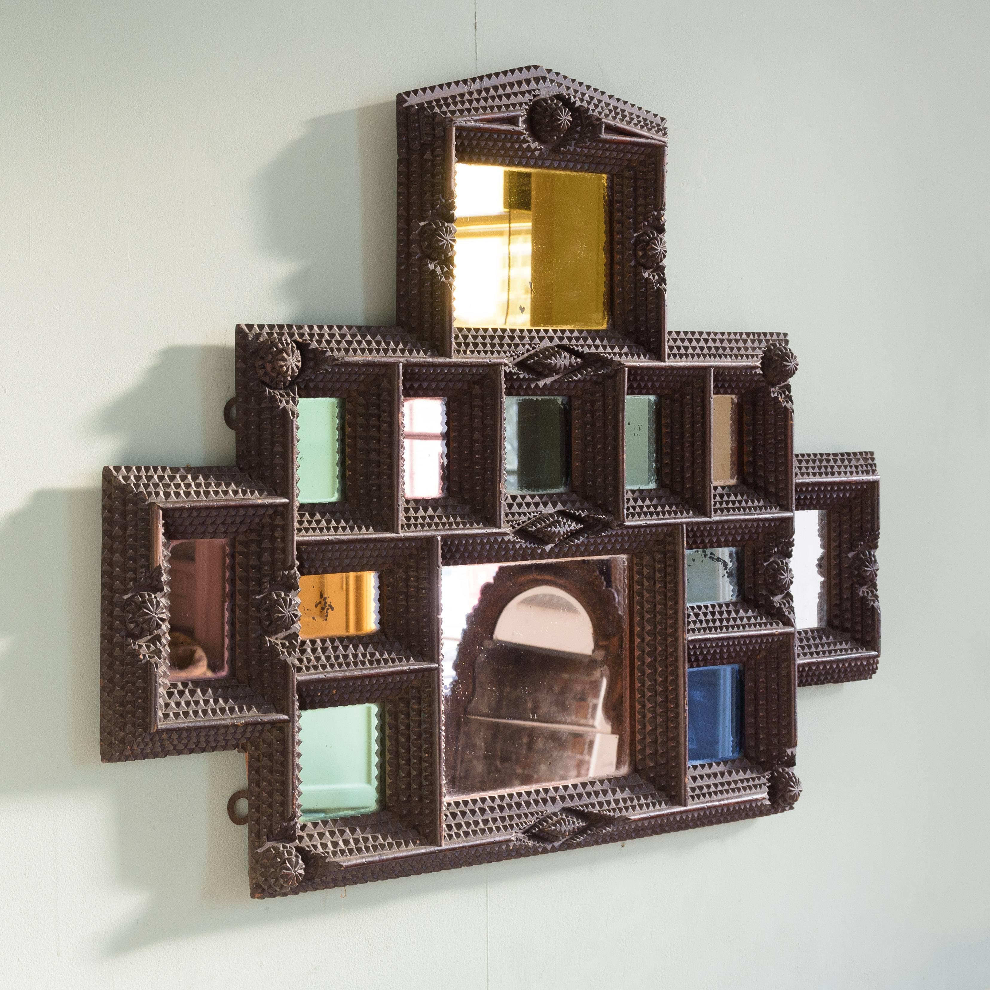 French (or possibly German) tramp art picture frame, circa 1890-1900, with all-over chip carving, with later inset colored mirror panels.

The name Tramp Art is misleading and is a modern re-branding of chip carved work made from found materials