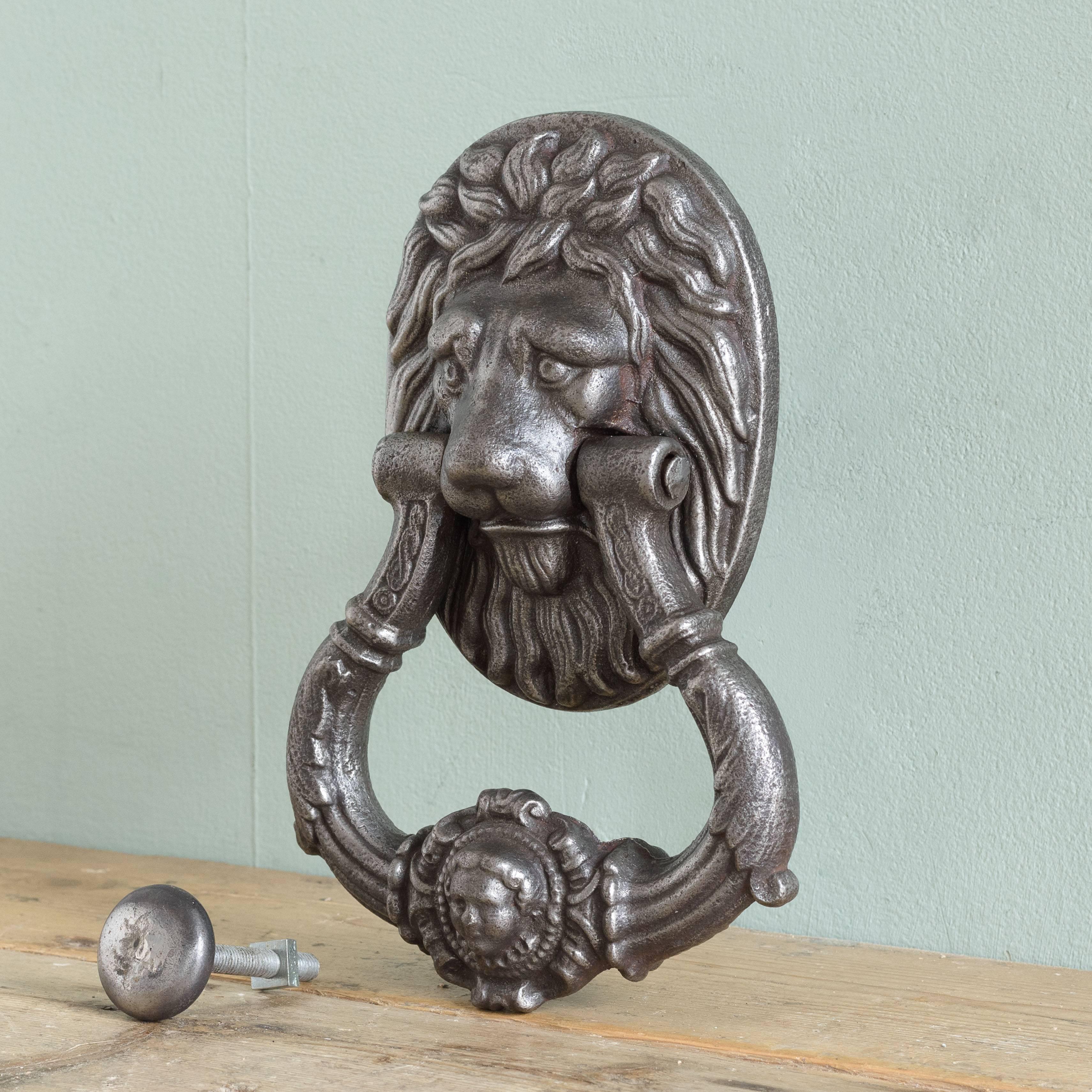 Early 19th century cast iron door knocker, formed of a lion's mask with clapper centered by male mask.

Similar examples can be found at Merrion Square, Dublin.