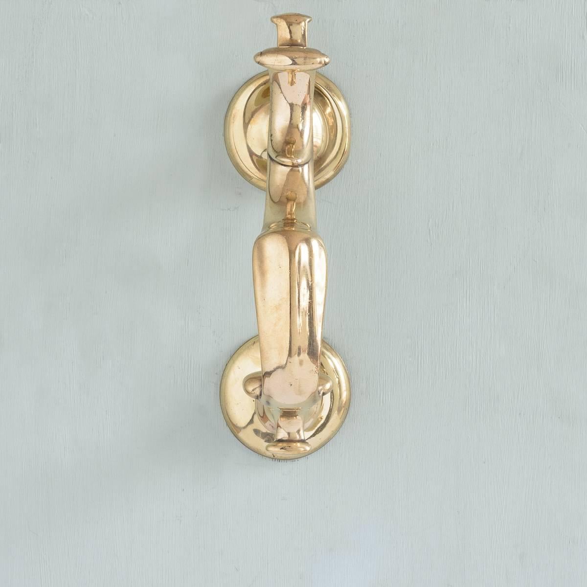An 18th century Georgian brass doctor's door knocker, circa 1780, with typical s-shaped scrolled rapper.