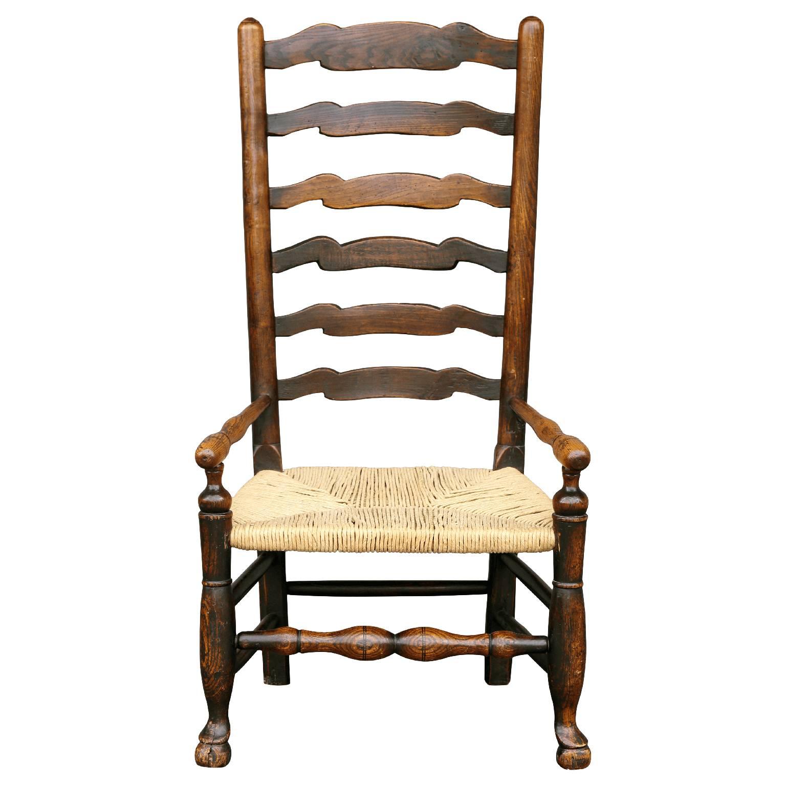 British country armchair in ash. This Georgian period chair's design is unusual and is attributed to an anonymous craftsman operating in the Lancashire parish of Wigan during the late 18th century. This chair features turned uprights, with domed and