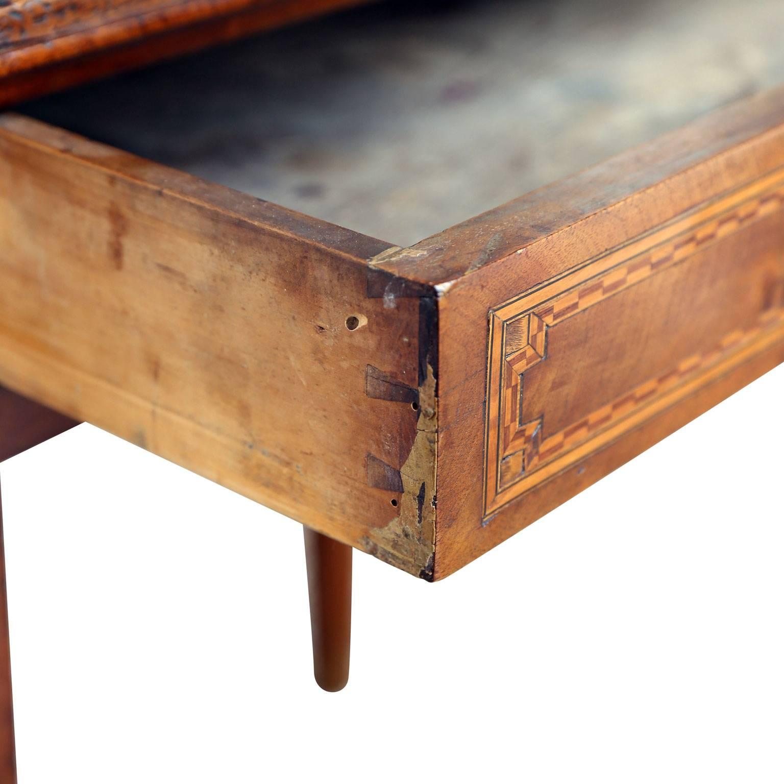 Early 19th century single drawer table, circa 1820-1840, in French walnut with satinwood, ebony and maple inlay.
  