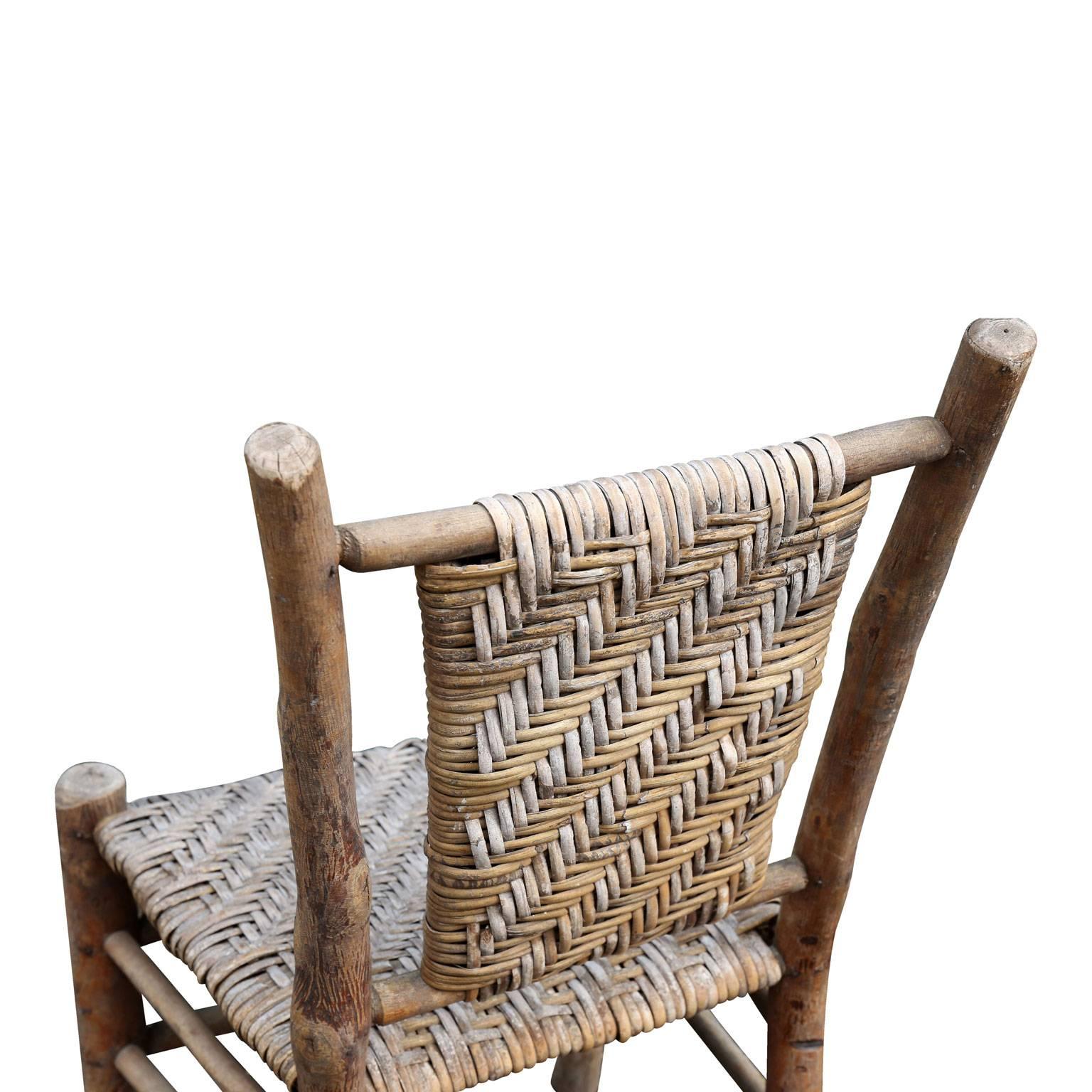 Old hickory side chair, made of natural wood and exposed bark, with its original handwoven seat and back and a beautiful patina that is a naturally sun-bleached brownish gray color. A genuine Folk Art piece created between 1933-1942 for the