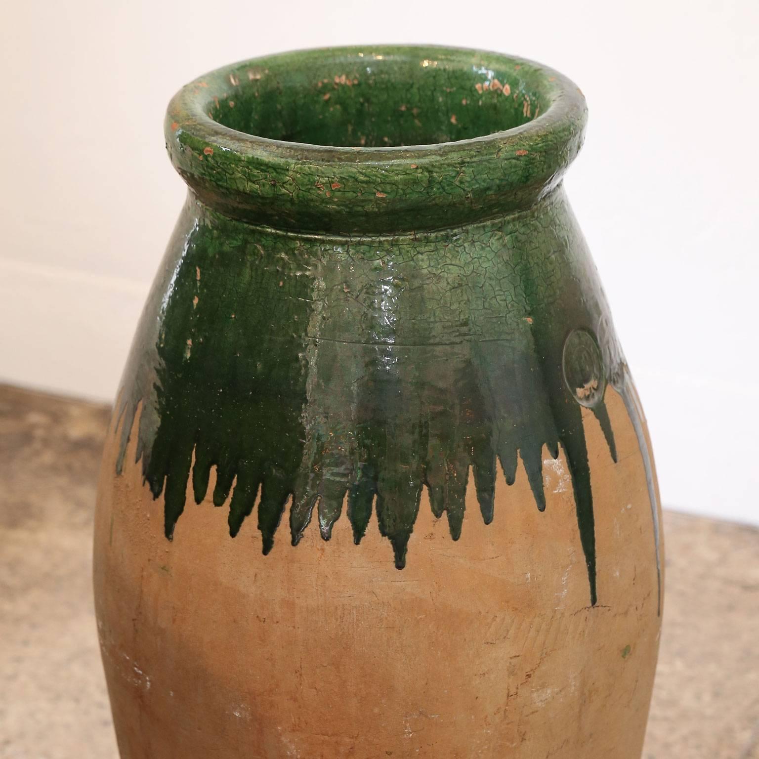 Green glaze terracotta jar with tall, tapered body and makers mark from late 19th century Provence, France.