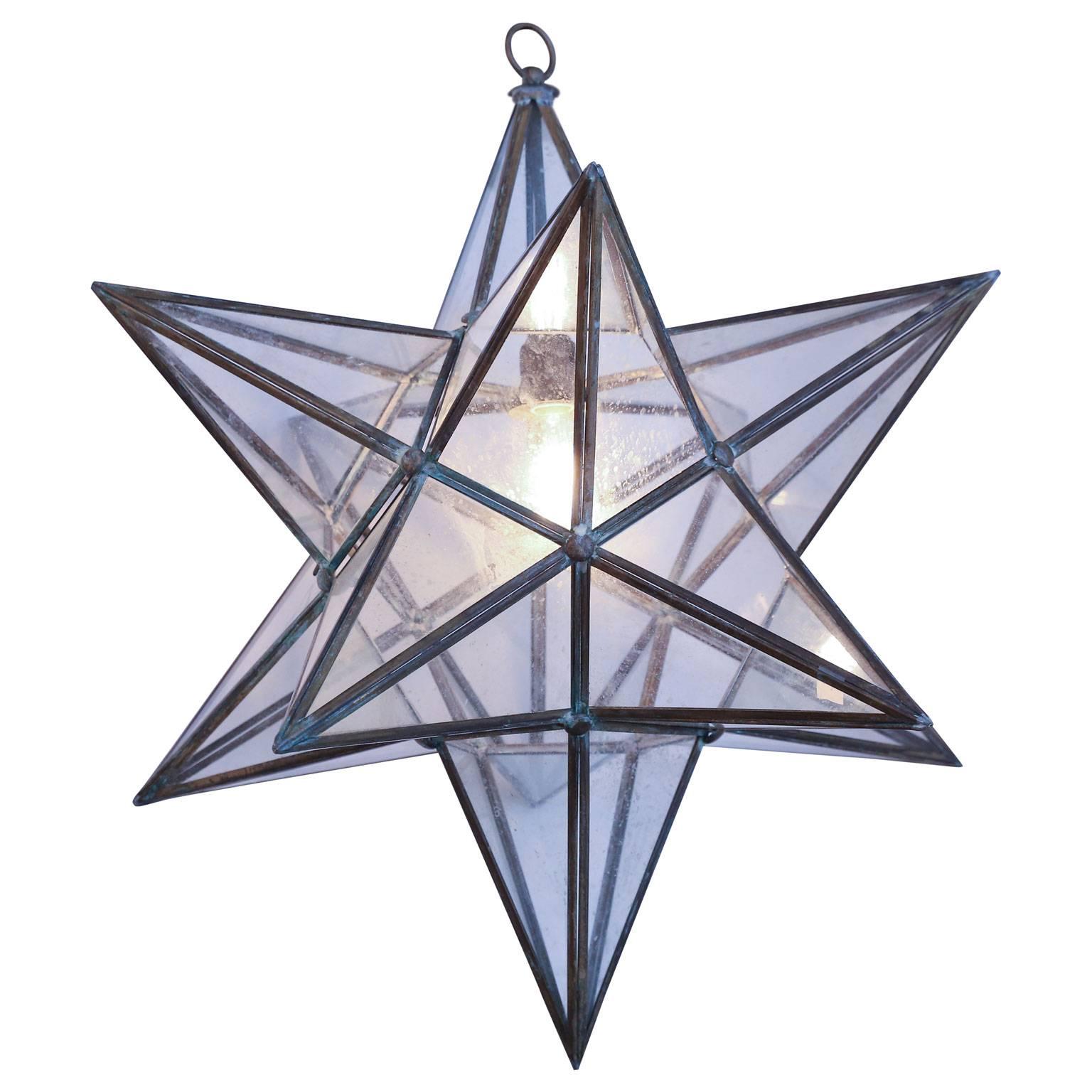 Two voluminous glass star pendants: multifaceted large Granada style lanterns with glass panels that form geometrical shapes similar to Moravian stars.