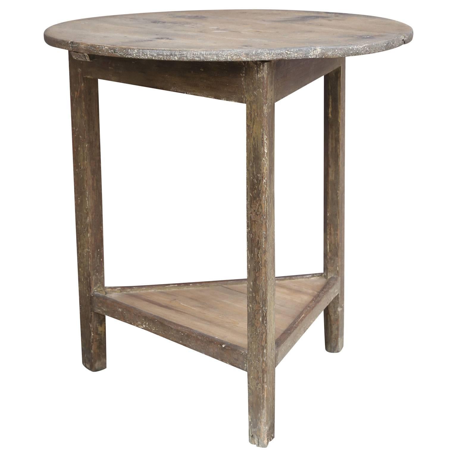 English pine cricket table with naturally scrubbed circular pine top, scrubbed under-shelf and faint remnants of original paint; perfect height and size to function as a side or end table. This table is in very good, correct condition and dates from