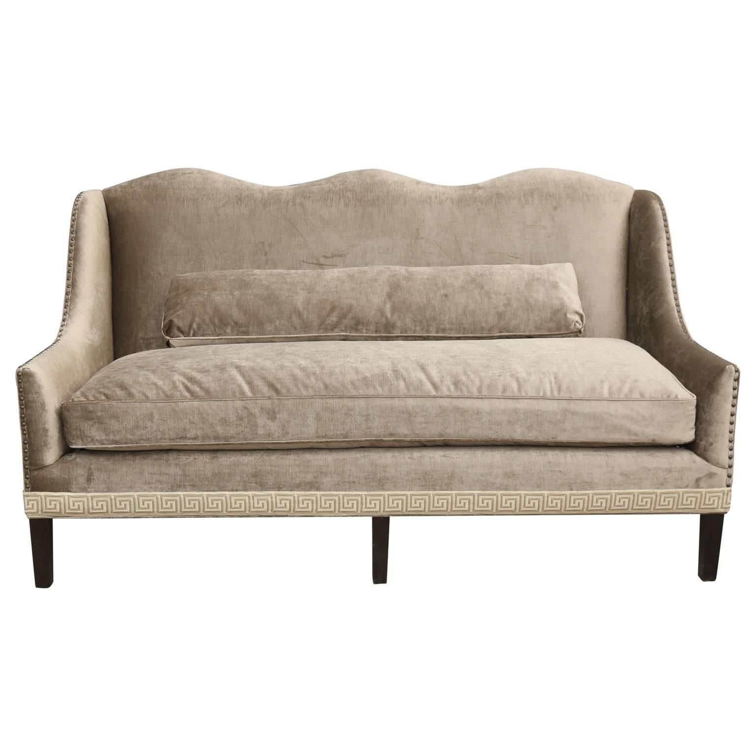 Classic vintage camel back sofa, newly-upholstered in a taupe-mushroom color velvet, and finished with nail heads and a Greek key tape trim. Seat measures 63 inches wide and 25 inches deep, with an arm height of 23 inches. Lumbar cushion is included.