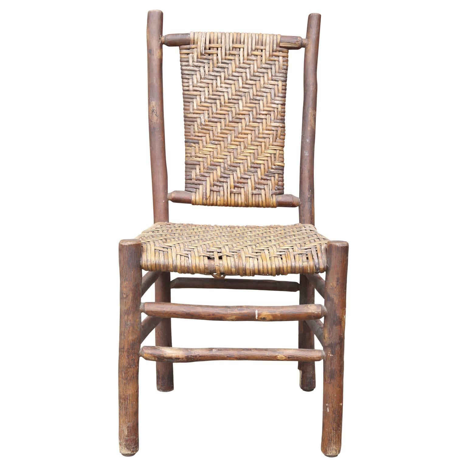 Old hickory side chair, made of natural wood and exposed bark, with its original handwoven seat and back and a beautiful subtle sun-bleached patina. A genuine Folk Art piece signed and created, circa 1933-1942, for the Adirondack civilian