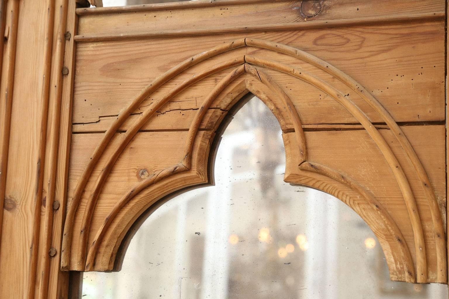 Pair of neo-gothic stripped pine mirrors dating to the late 19th century, (circa 1850-1870). French in origin. Each frame contains its original mercury-backed silvered two-panel mirror. Attractive 'diamond dust' covers both mirrors' edges. Sold
