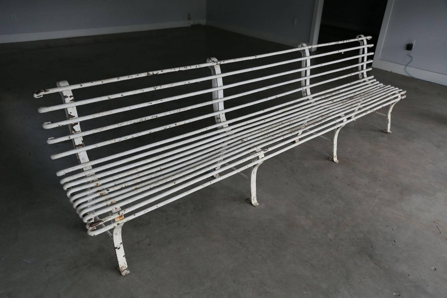 Long French iron bench in early white paint. Excellent example of early 20th century quality French cast and wrought iron. In stabile, sturdy good condition and a nice heavy weight. Ready to be installed in your garden or outdoor space.